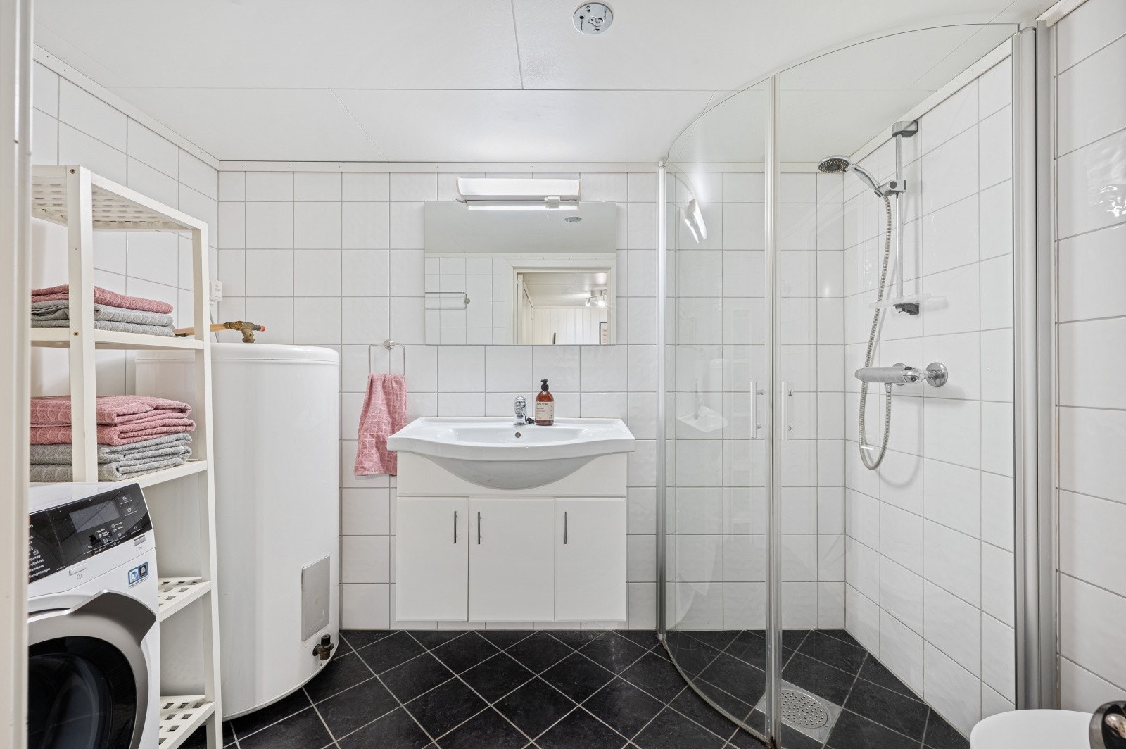 I kjeller er det flislagt bad med dusjhjørne og romslig oppbevaring. Dette rommet er på originale tegninger bod. Galleribilde