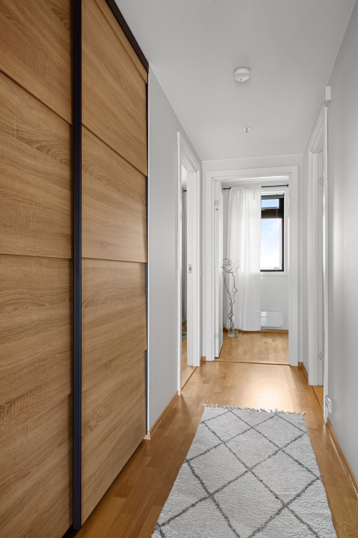 Gang med praktisk skyvedørsgarderobe Galleribilde