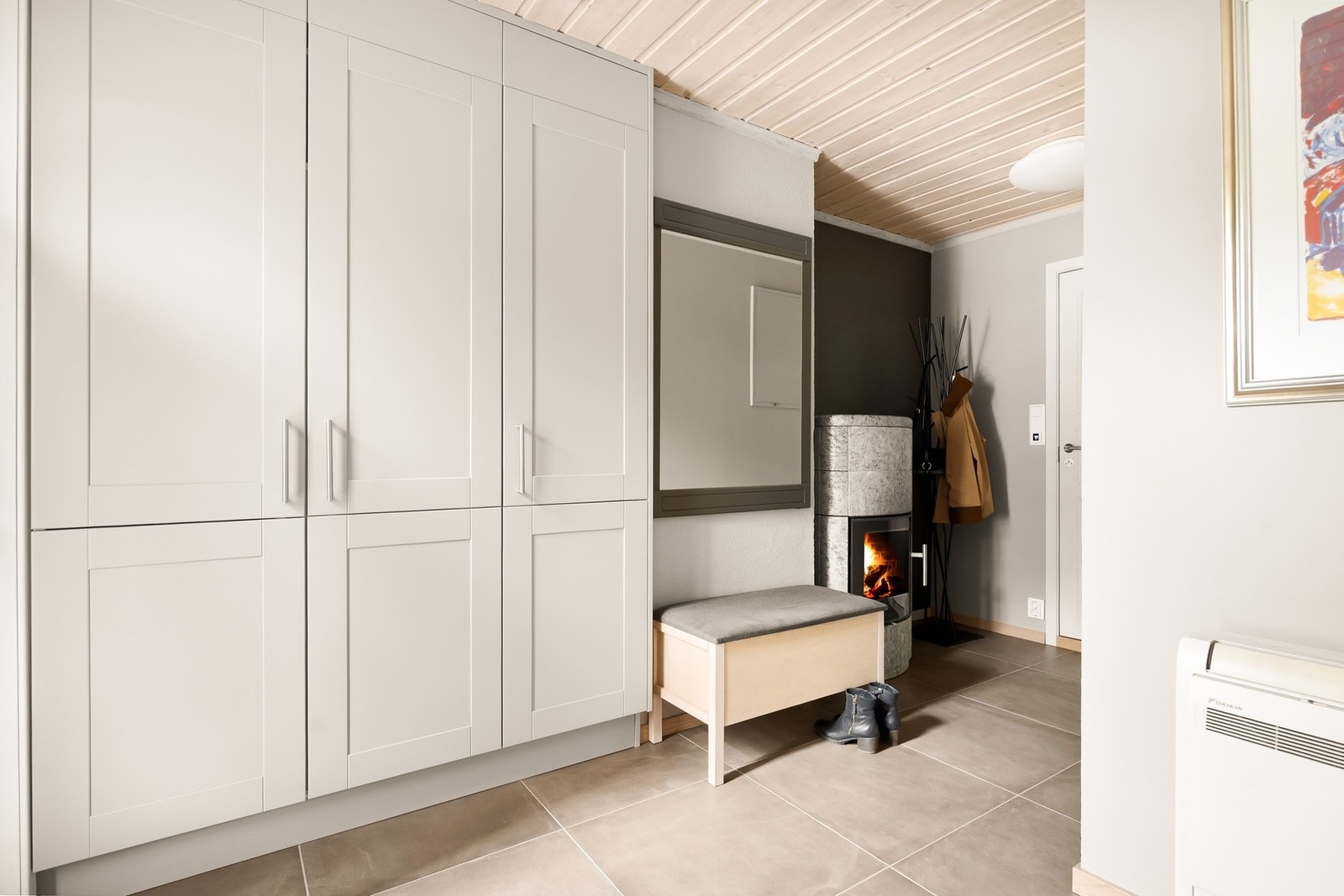 Entréen har godt med oppbevaringsplass og god plass til yttertøy og sko samt en kleberstensovn som gir lun og god varme i store deler av huset. Galleribilde