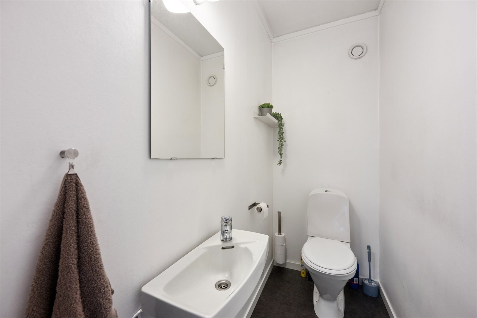 Like ved baderommet finner man et toalettrom som er innredet med belegg på gulv og malte veggflater. Rommet er ellers utstyrt med toalett og servant. Galleribilde