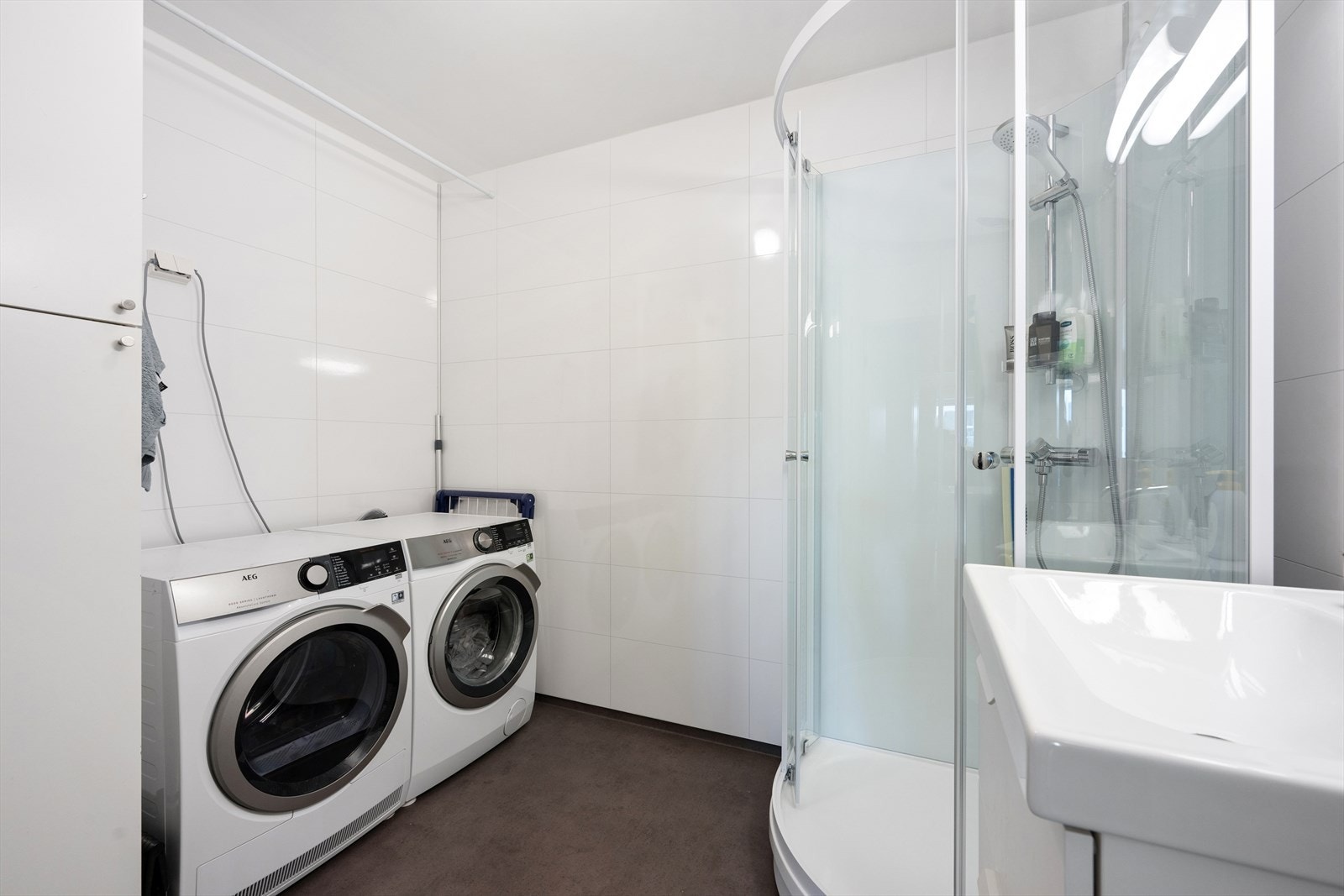 Badet er fra 2020 og er tidløst innredet med grått vinylbelegg på gulv og hvite våtromsplater på vegg. Badet er ellers utstyrt med dusjkabinett og baderomsinnredning med nedfelt servant. I tillegg er det opplegg for vaskemaskin og plass til tørketrommel. Galleribilde