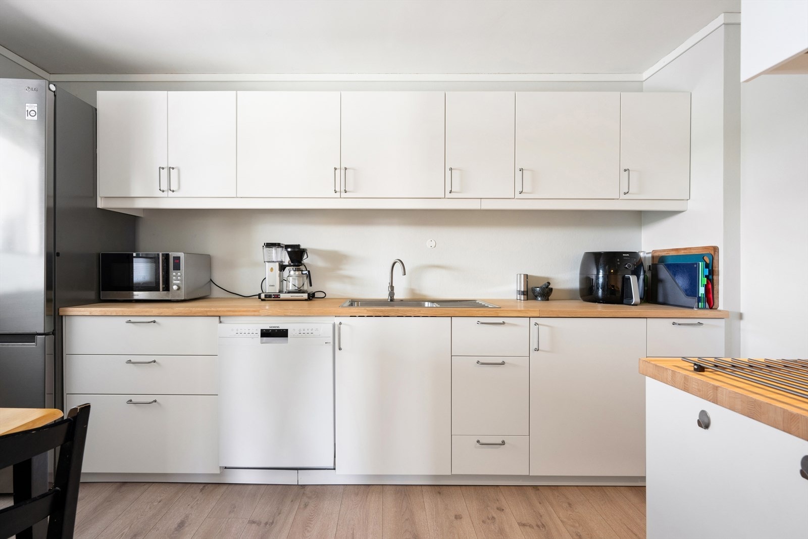 Kjøkkenet er levert av Ikea og var nytt i 2020. Et tidløst innredet kjøkken med hvite, slette fronter og trefarget benkeplate i laminat. Galleribilde