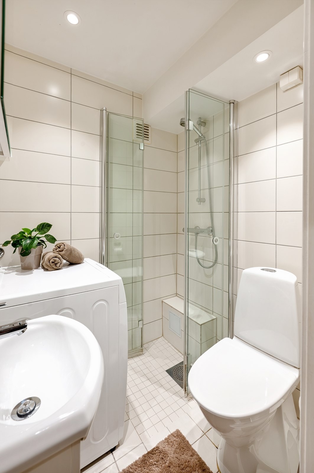 Badet er utstyrt med baderomsinnredning med heldekkende servant og speil på vegg, toalett og dusj med innfellbare dusjvegger. Galleribilde