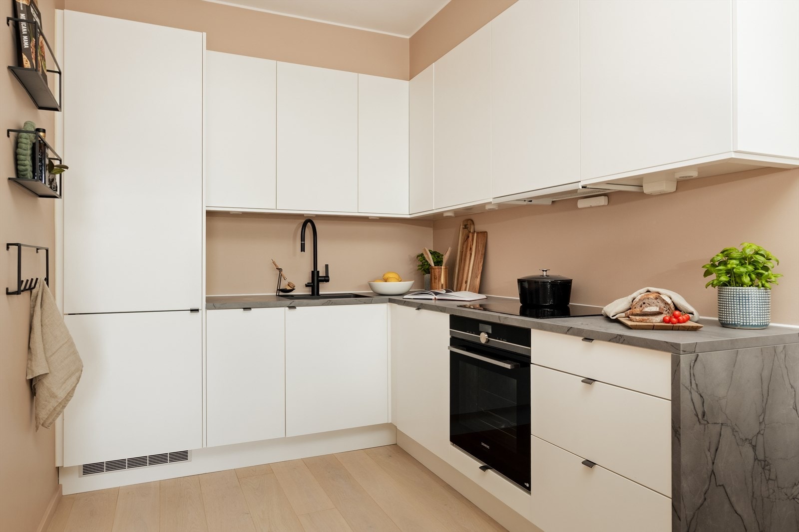Overflatene består av glatte, hvite fronter og benkeplate i laminat. Galleribilde