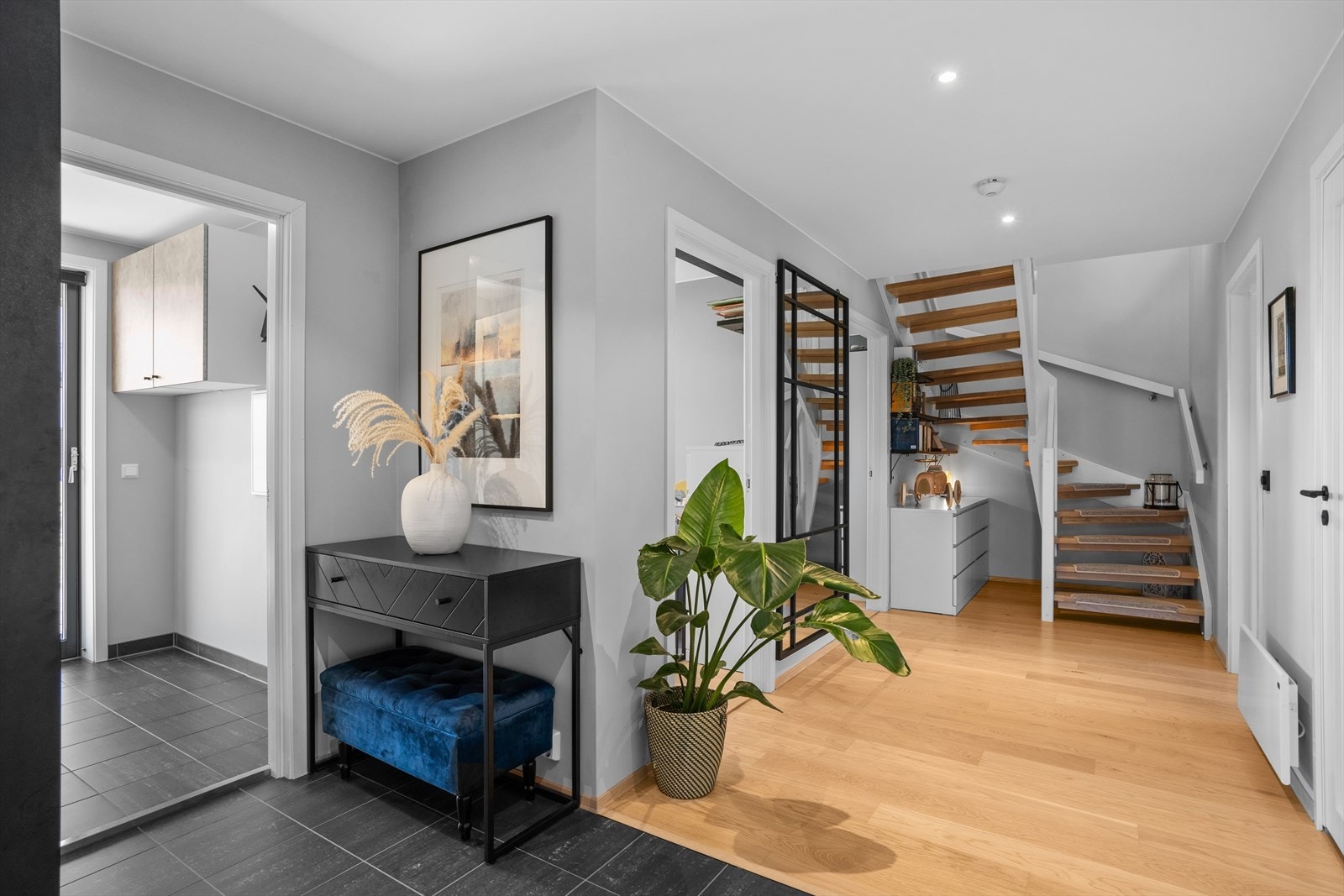 Romslig gang og entré med delvis flislagt gulv, varmekabler og downlightsbelysning. Galleribilde