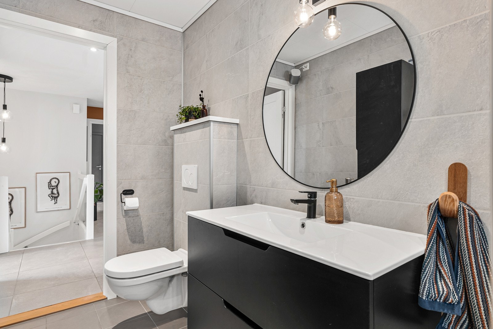 Badet er innredet med dusjhjørne, vegghengt toalett og baderomsmøblement. Galleribilde