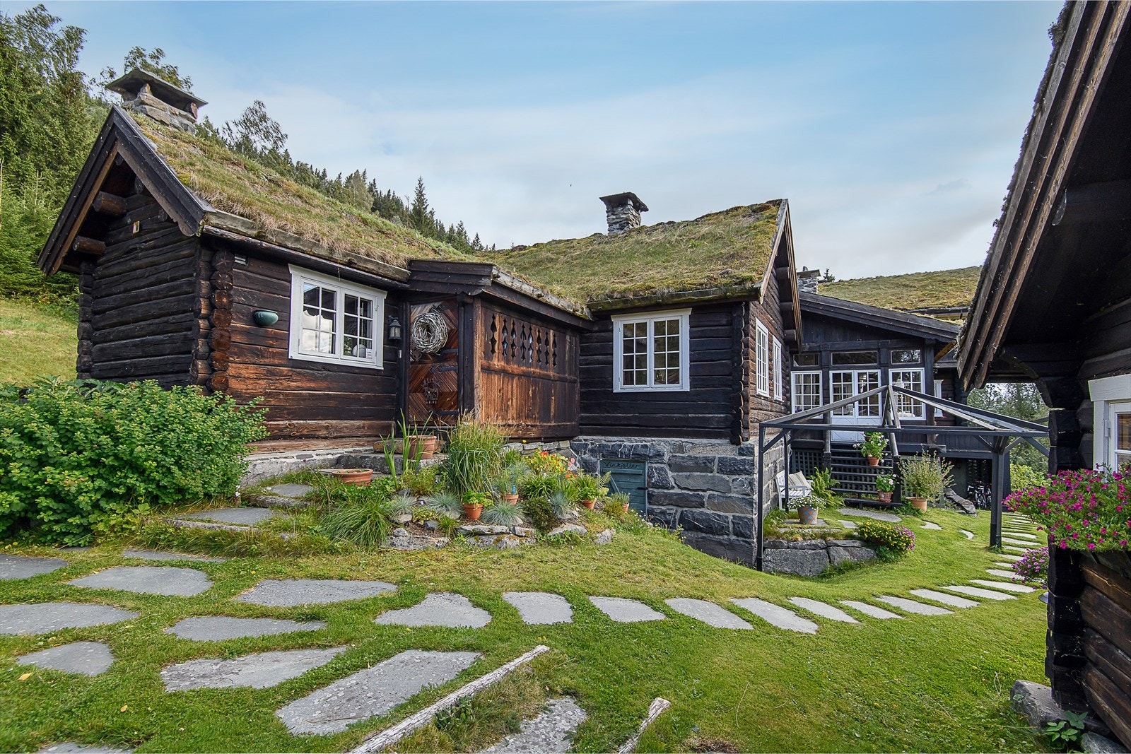 Mellom bygningene er det steinlagte stier som skaper et hyggelig og tradisjonelt tunmiljø. Galleribilde