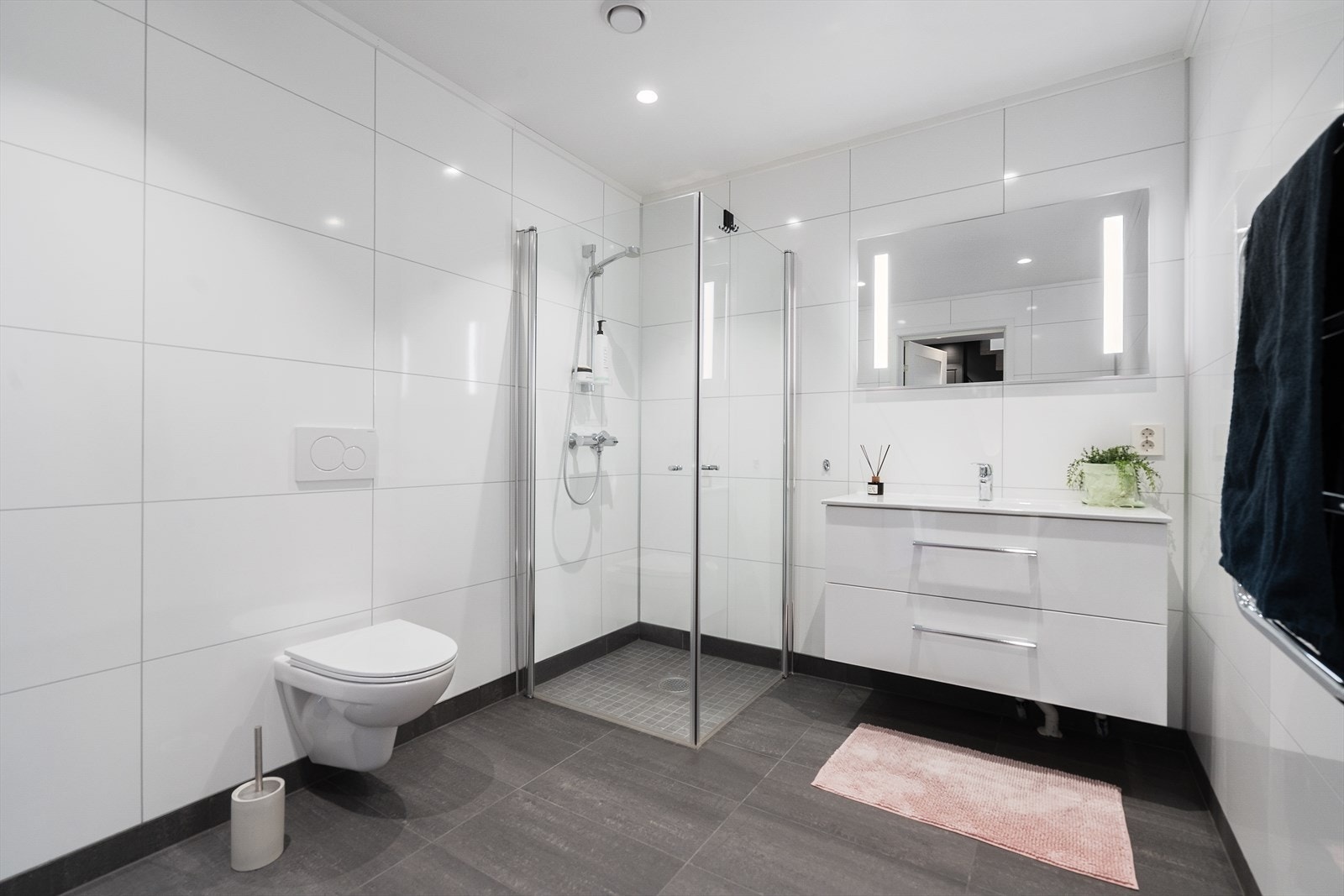 Hovedbadet i underetasjen er av god størrelse og innredet med hvit baderomsinnredning, speil med led belysning, vegghengt toalett og dusjhjørne. Galleribilde
