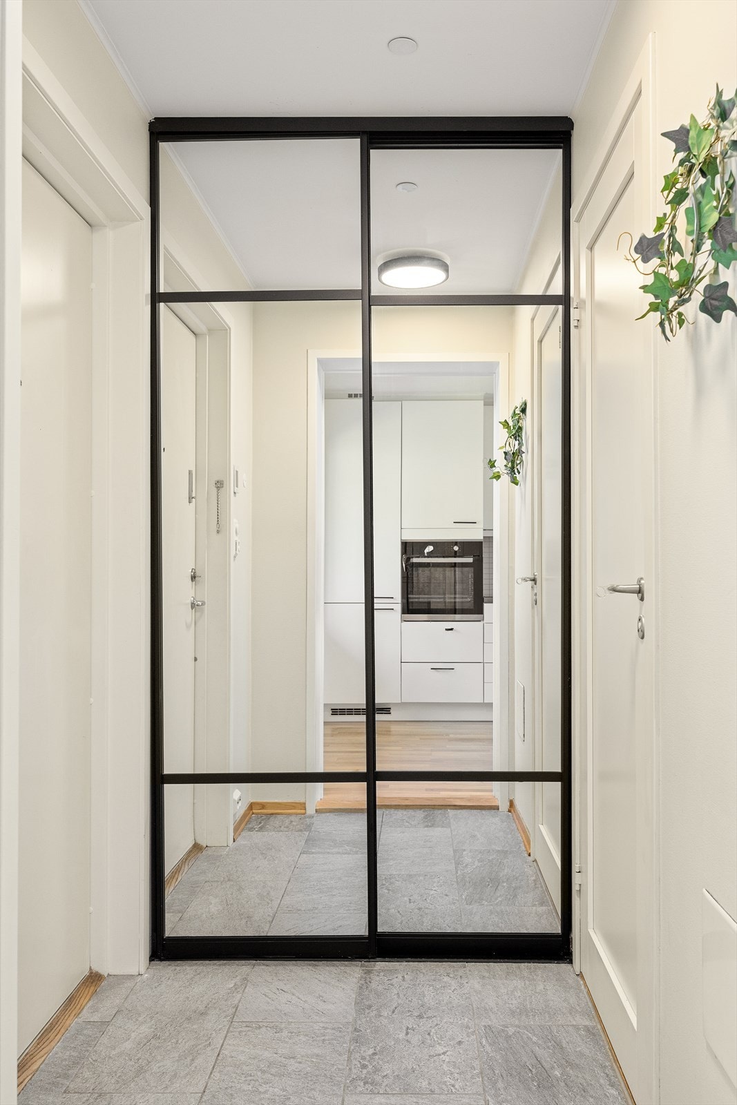 I entreen er det en stilig skyvedørsgarderobe med speilfronter og sorte detaljer. Galleribilde