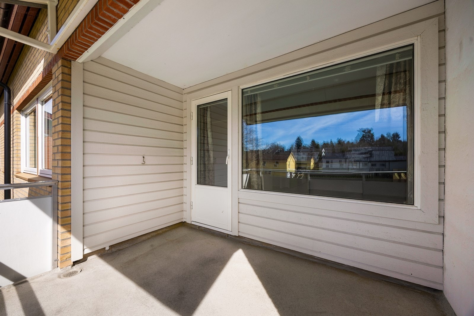 Balkongen er oppført i betong og har rekkverk av stål/aluminium med fasadeplater. Verandadør fra 2000. Galleribilde