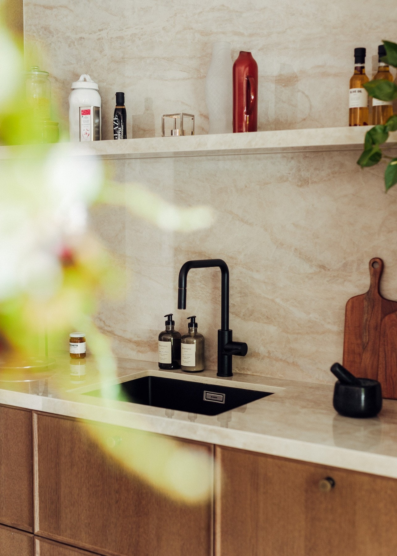 I bankkant av vask og kum finner du også Dekton Arga benkeplate. Den strekker seg helt opp til taket og har en hylle i samme materiale med integrert ledstripe i underkant av hyllen. Galleribilde