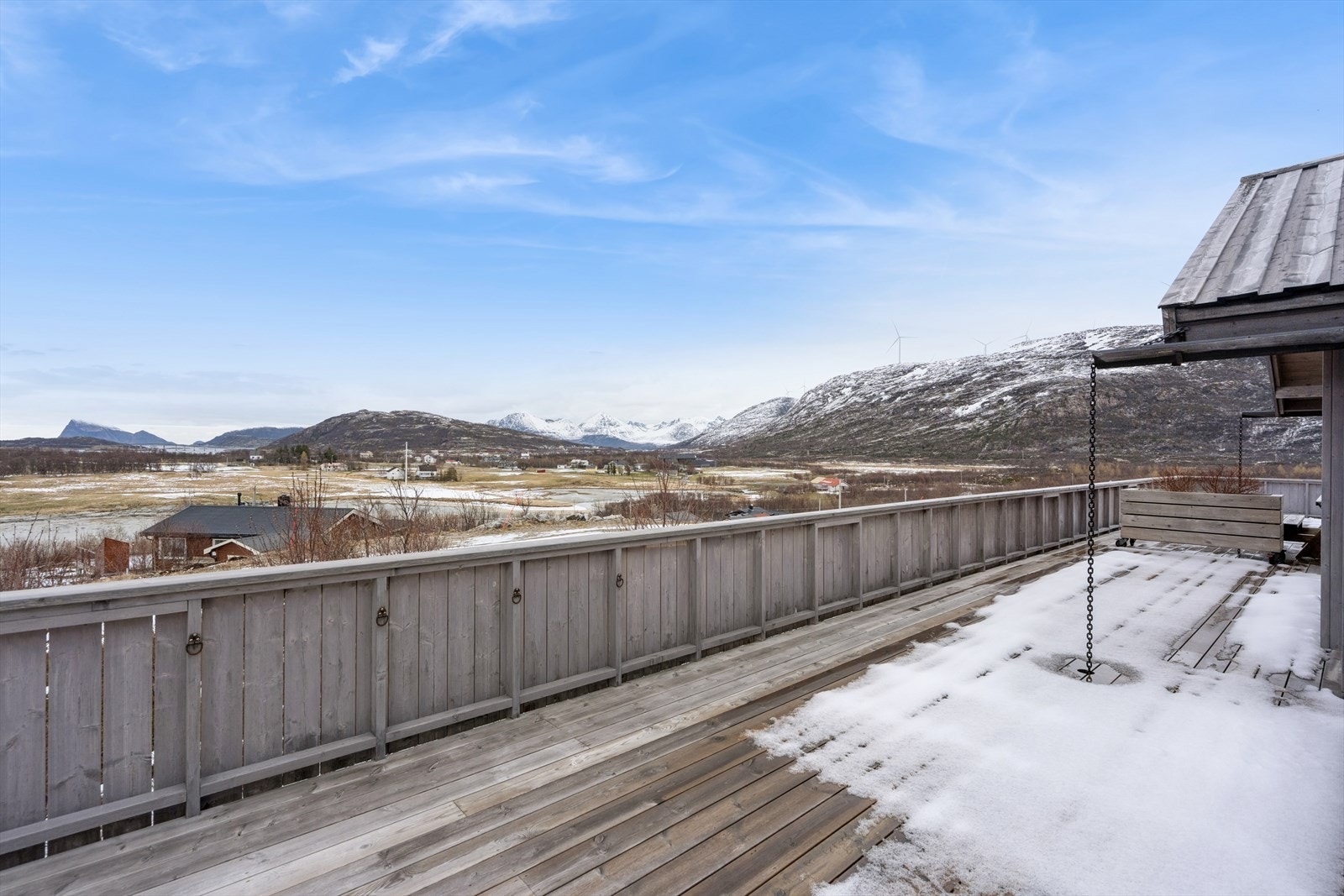 Terrassen har et beiset rekkverk i tre. Galleribilde