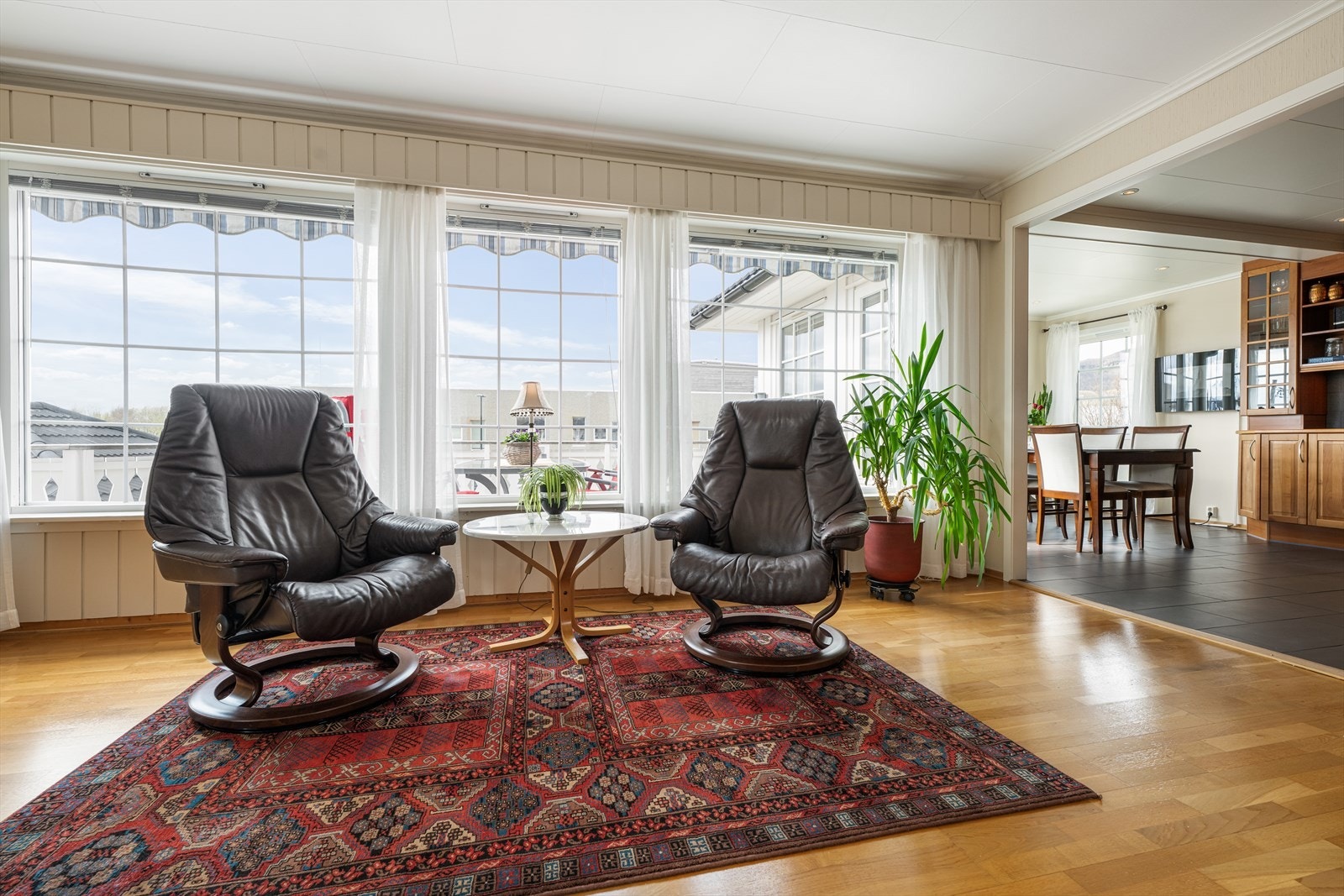 Store vindusflater tilføyer rikelig med naturlig lysinnslipp i rommet. Videre tilkomst til kjøkkenet fra stuen. Galleribilde