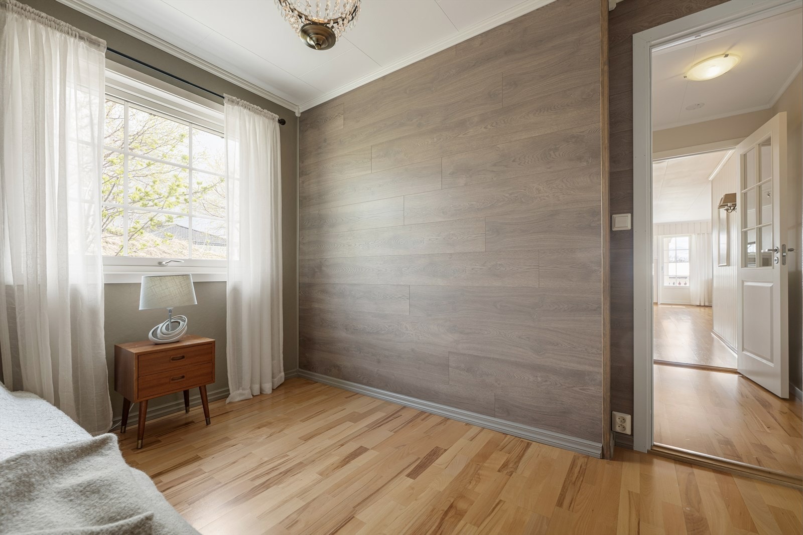 Fin kontrastvegg med panel, og parkett på gulv. Galleribilde