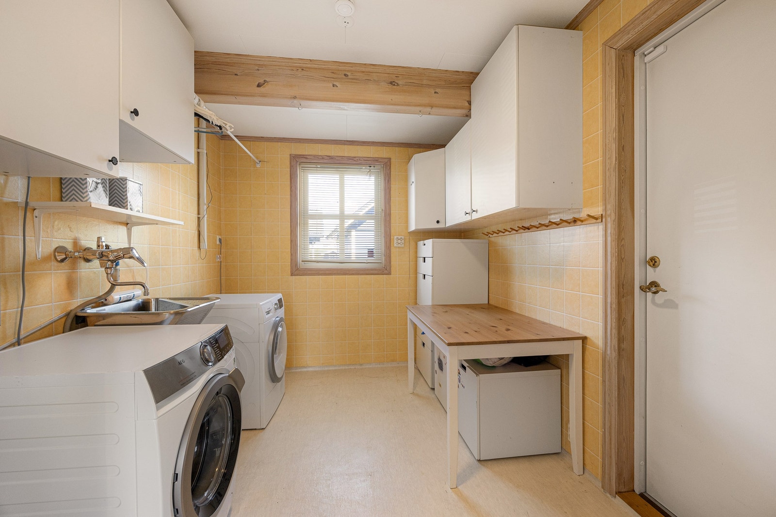 Praktisk vaskerom med opplegg for vaskemaskin, egen vaskekum og god skapplass. Galleribilde