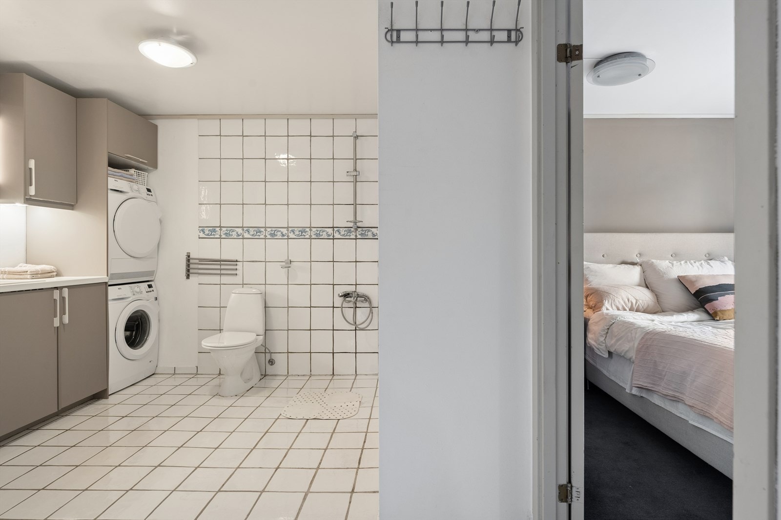 I tilknytning til soverommet finner man det andre baderommet som er kombinert med vaskerom. Baderommet er fra byggeår og er innredet med lyse fliser på gulvet og en kombinasjon av lyse fliser og tapetserte flater på vegg. Varmekabler i gulvet. Galleribilde