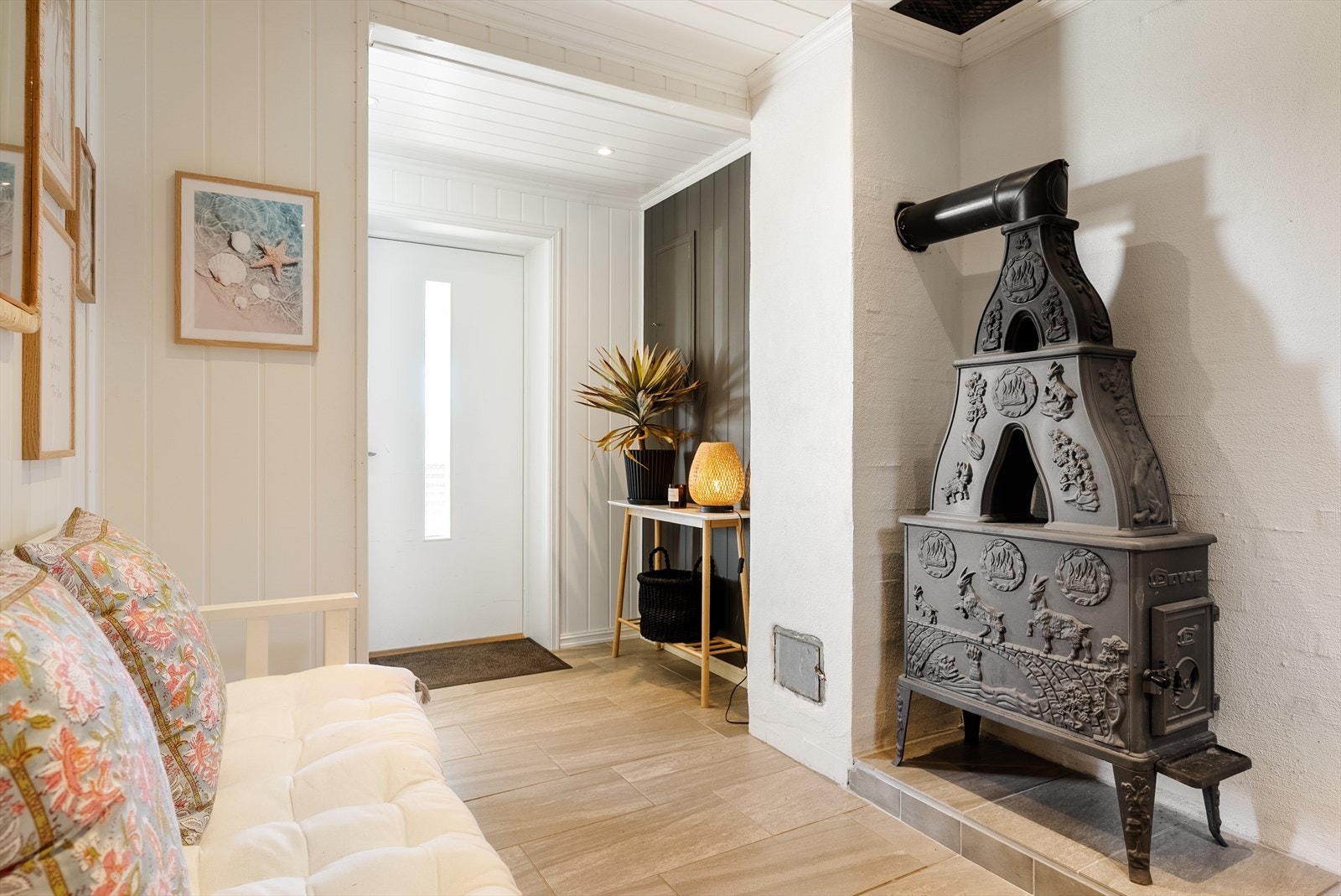 En innbydende entré med en klassisk vedovn som gir varme og karakter til rommet. Galleribilde