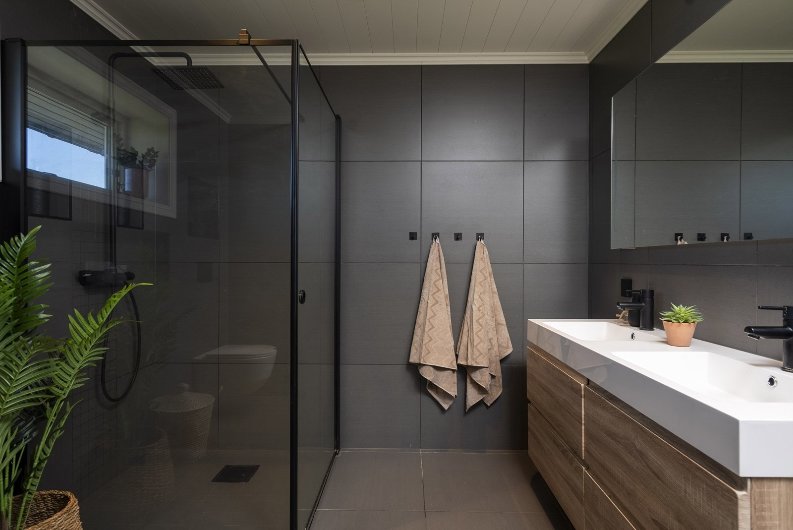 Badet er utstyrt med en bred servantinnredning med to nedfelte servanter, og har elektriske varmekabler i gulvet. Galleribilde