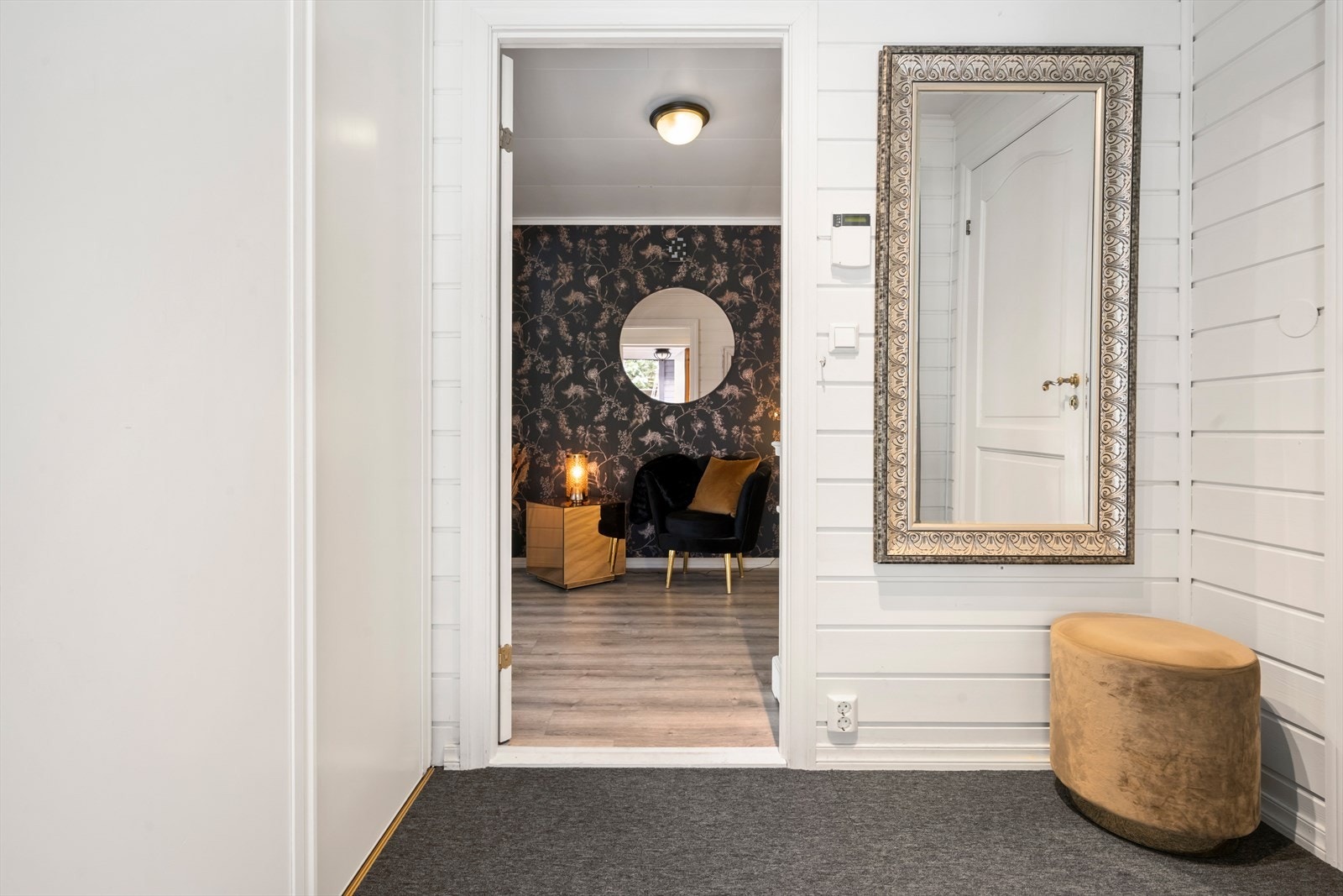 Vindfanget har flislagt golv under teppet og leier vidare inn til ein romsleg gang. Galleribilde