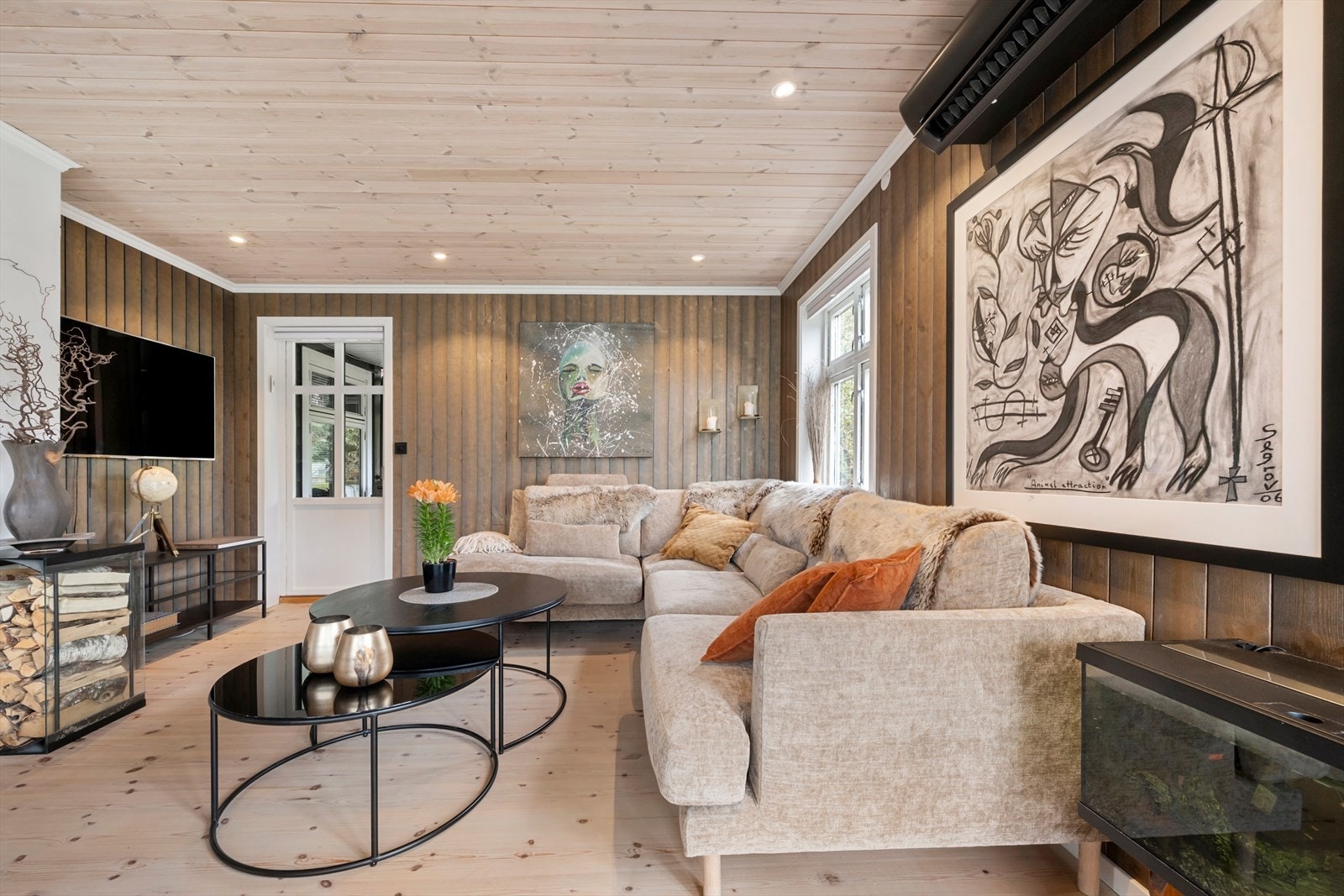 Vegger med beisa trepanel og downlights i taket gir stova ein lun karakter. Galleribilde