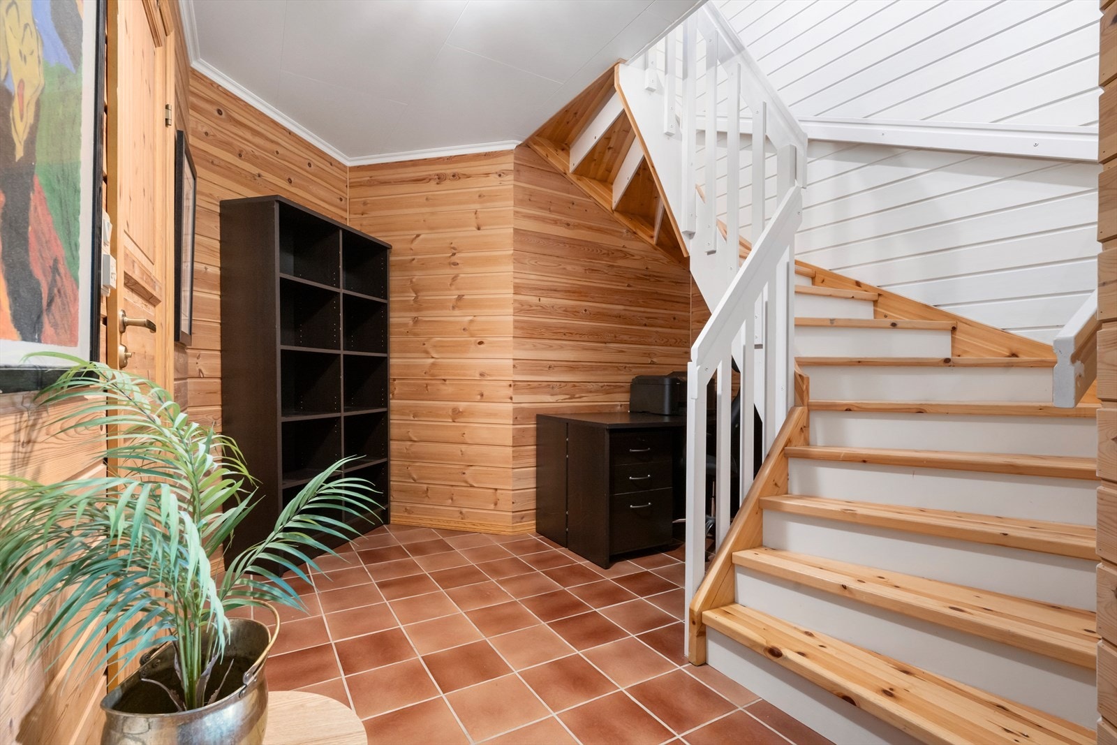 Tretrappa med lakkerte trinn knyter dei to etasjane saman. Galleribilde
