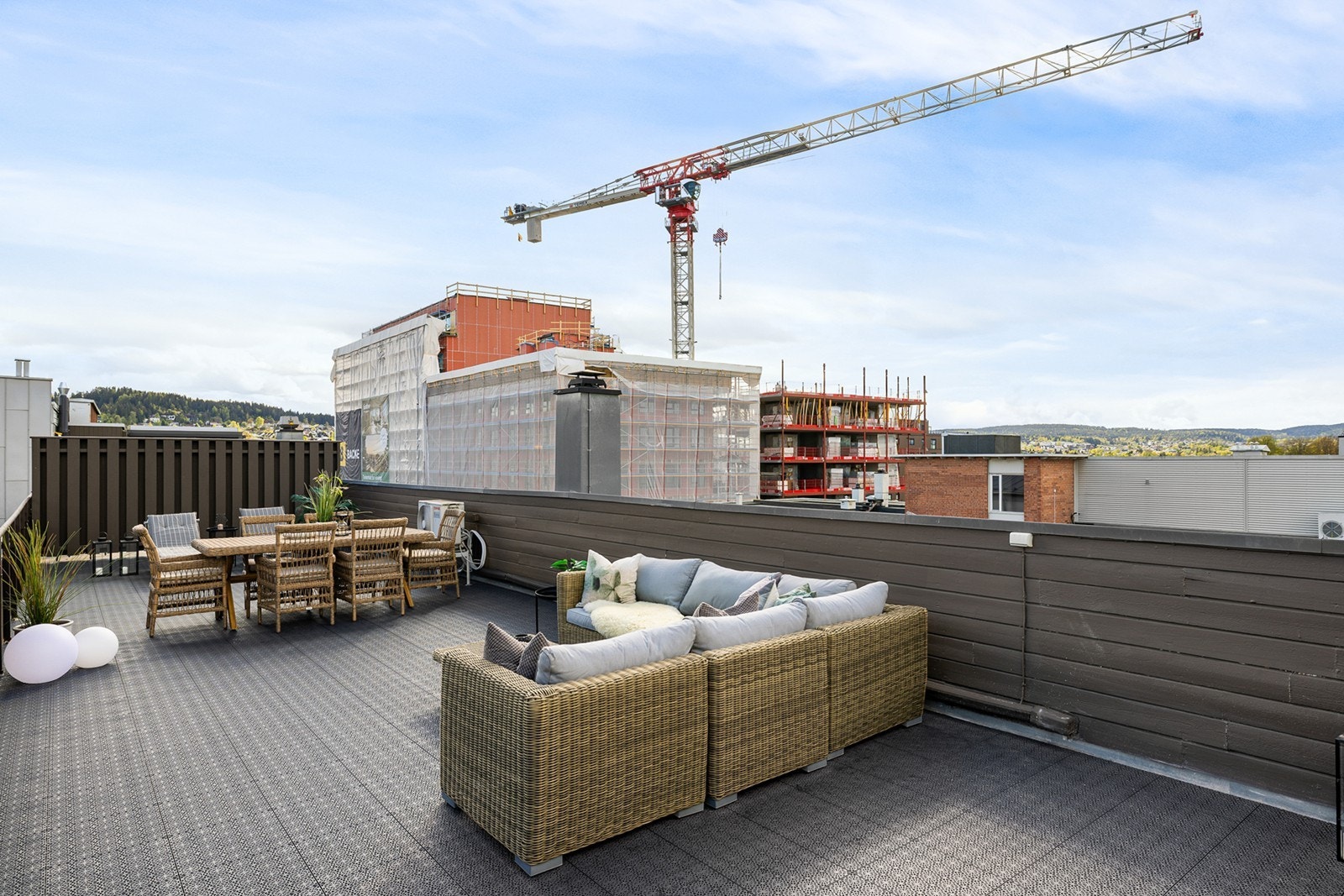 Takterrassen er skjermet med levegger mot naboene på begge sider, noe som gir gode private soner og lun atmosfære. Langsidene er sikret med rekkverk, og terrassen har god plass til både spisegruppe og loungeområde. Galleribilde