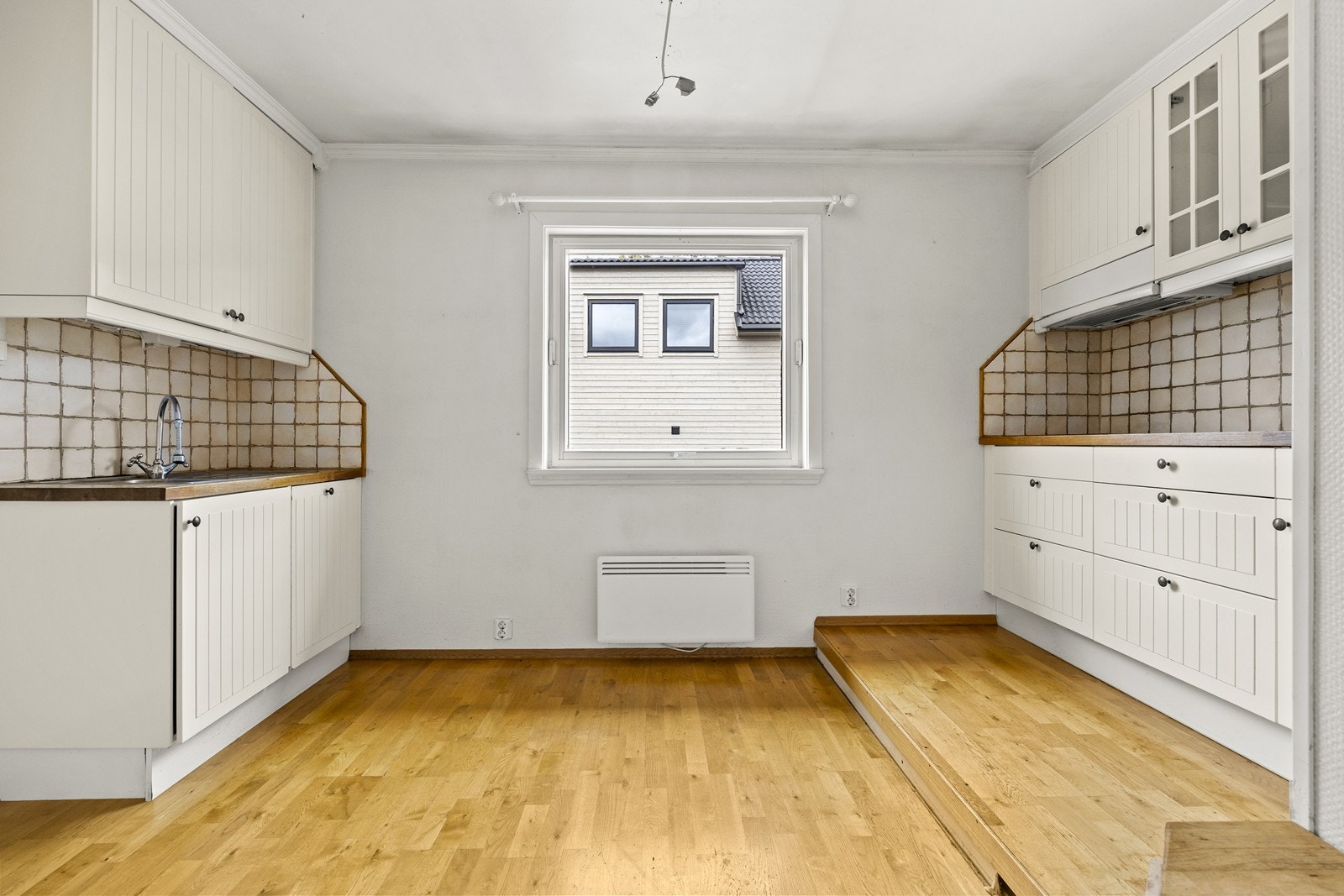 Boligens andre kjøkken har profilerte fronter og benkeplate i treverk. Dette rommet har av dagens eier vært lite brukt. Galleribilde
