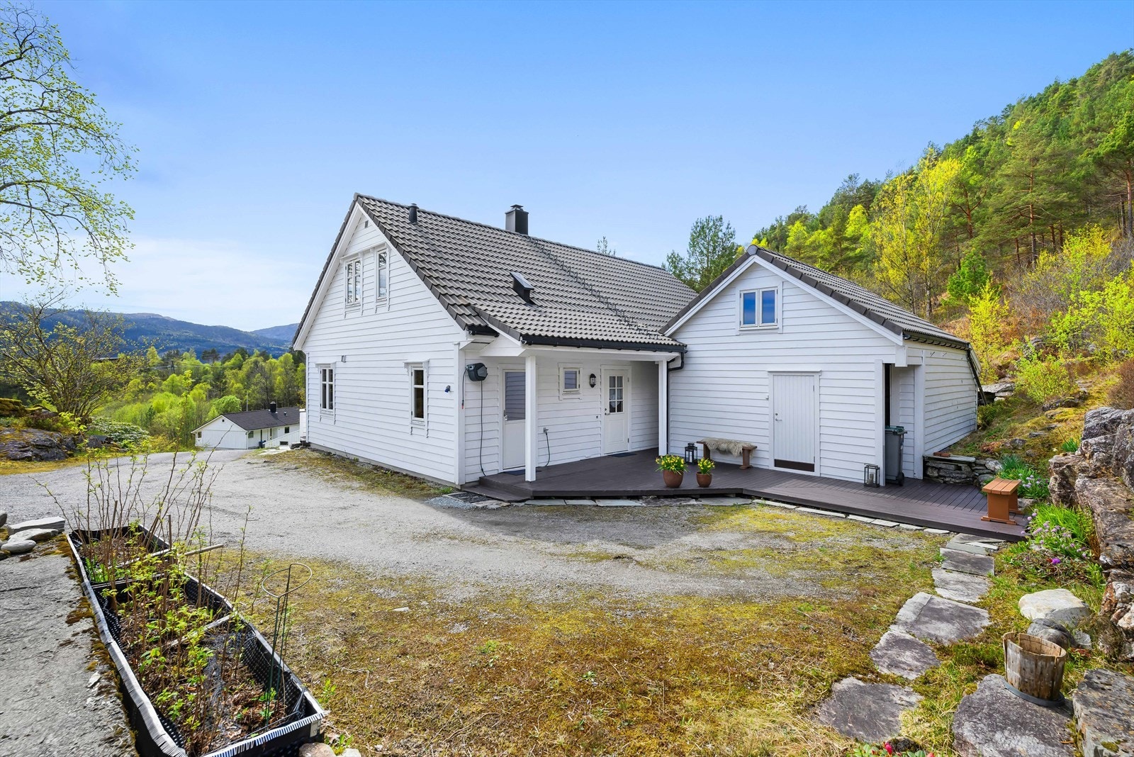 Eneboligen ligger høyt og fritt med en stor, gruset gårdsplass. Galleribilde