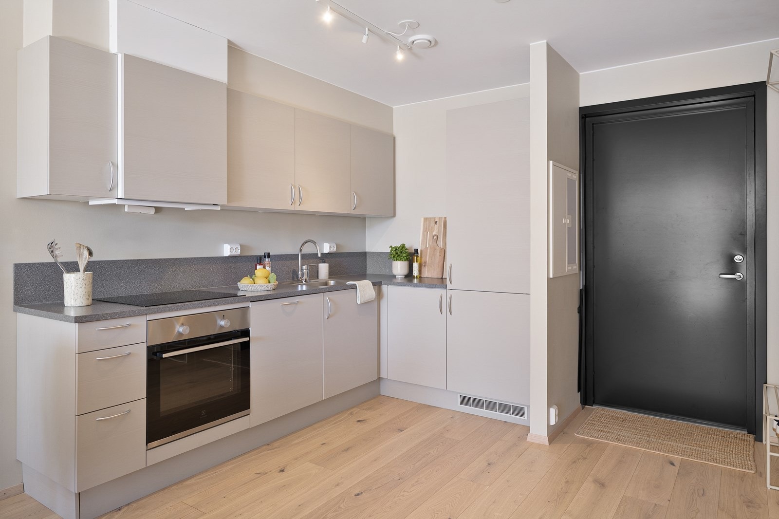 Kjøkkeninnredning med glatte fronter, laminatbenkeplate og avtrekk koblet til det balanserte ventilasjonsanlegget Galleribilde