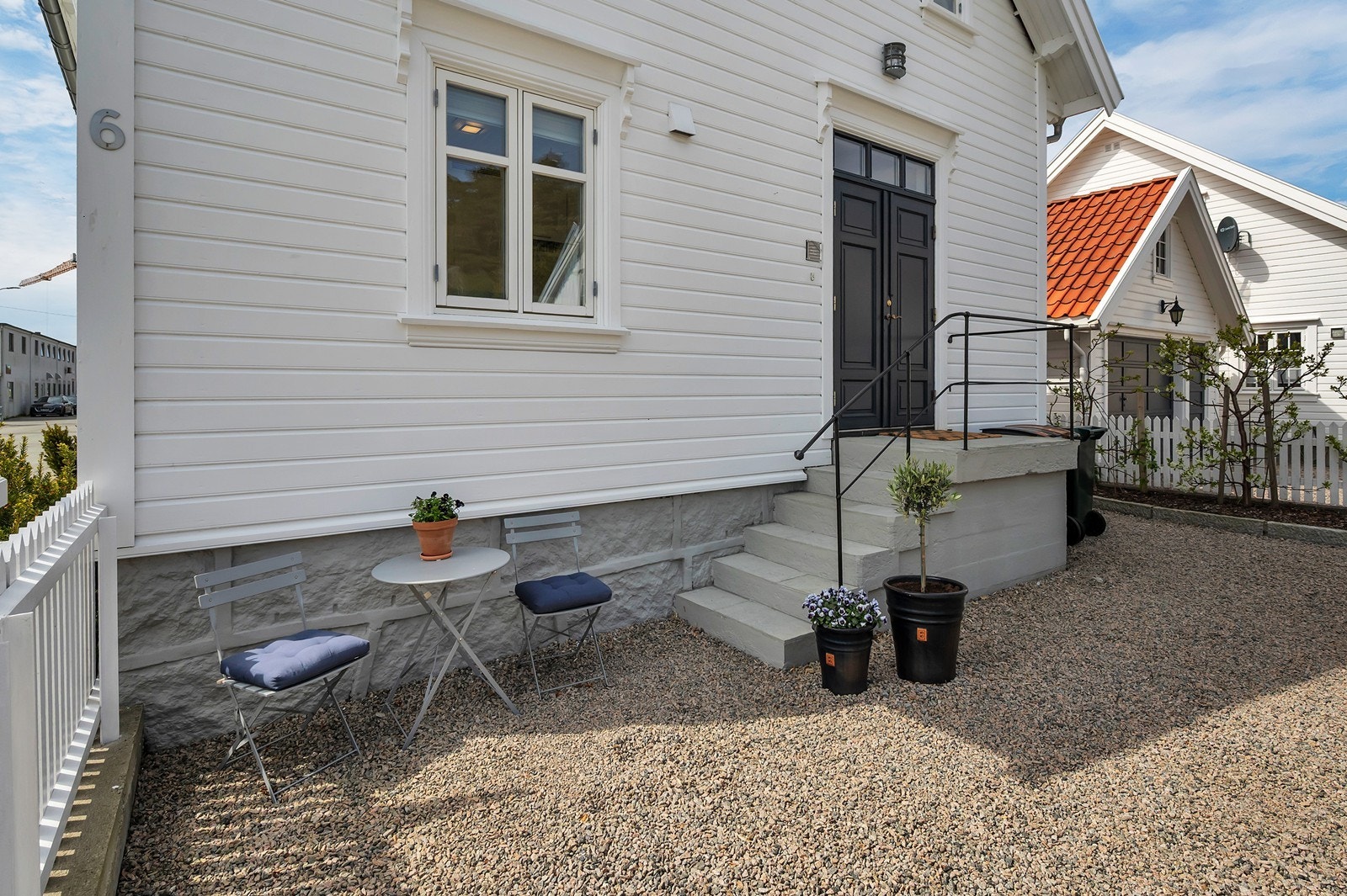 Inngangspartiet har en støpt trapp med fliser i trinnene og rekkverk av støpejern. Galleribilde