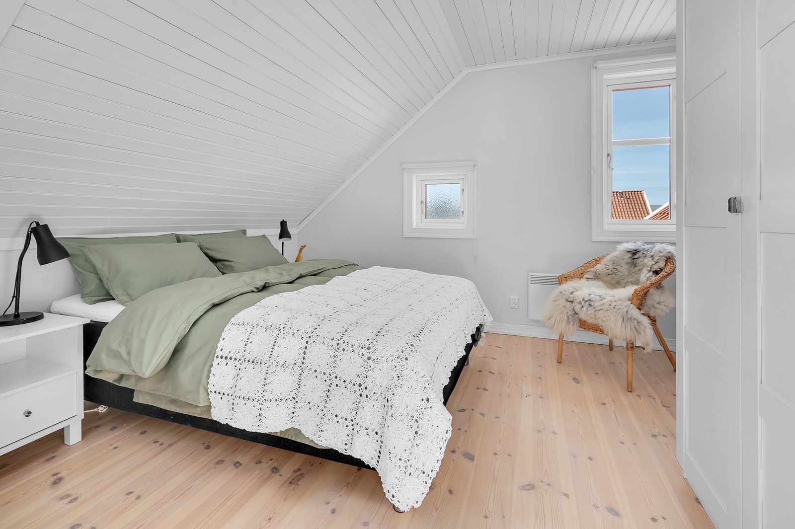 Det ene av to soverom på loftet, med sjarmerende skråtak og furugulv. Galleribilde