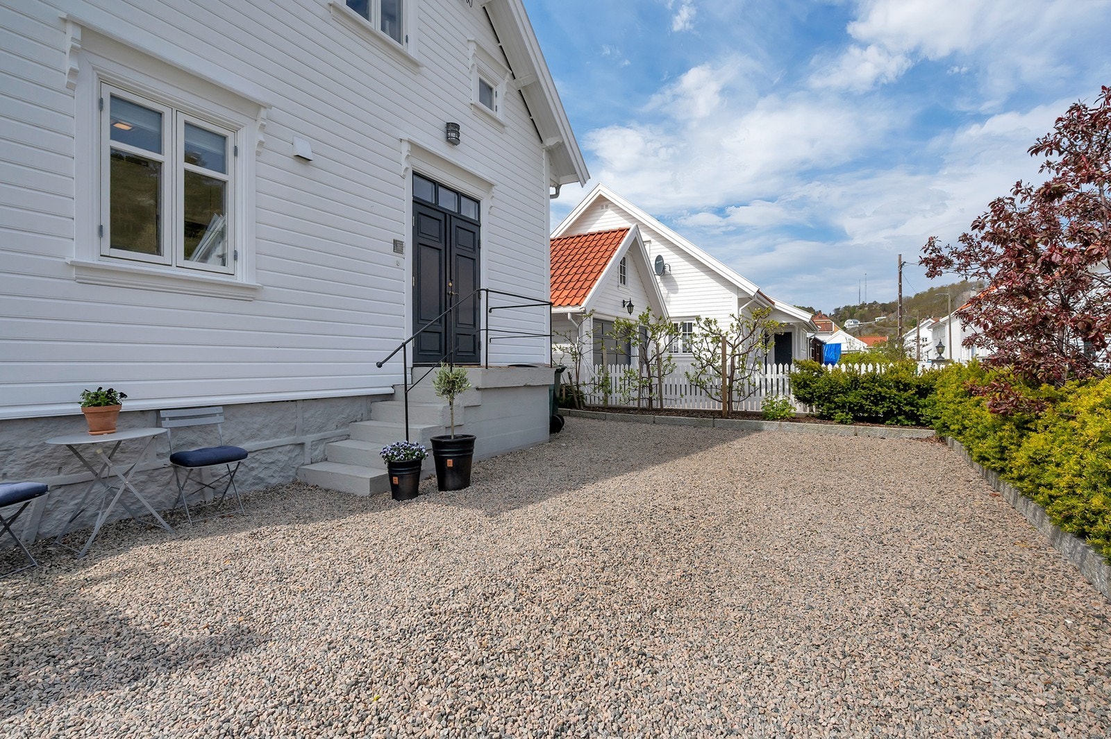 Tomten er opparbeidet med plen, beplantning og en innrammet gårdsplass. Galleribilde