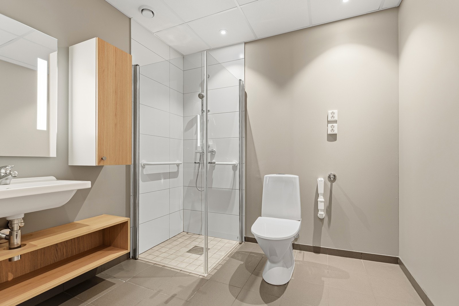 Badet er fra opprinnelig byggeår og inneholder dusjhjørne med glassdører, servantinnredning og toalett Galleribilde