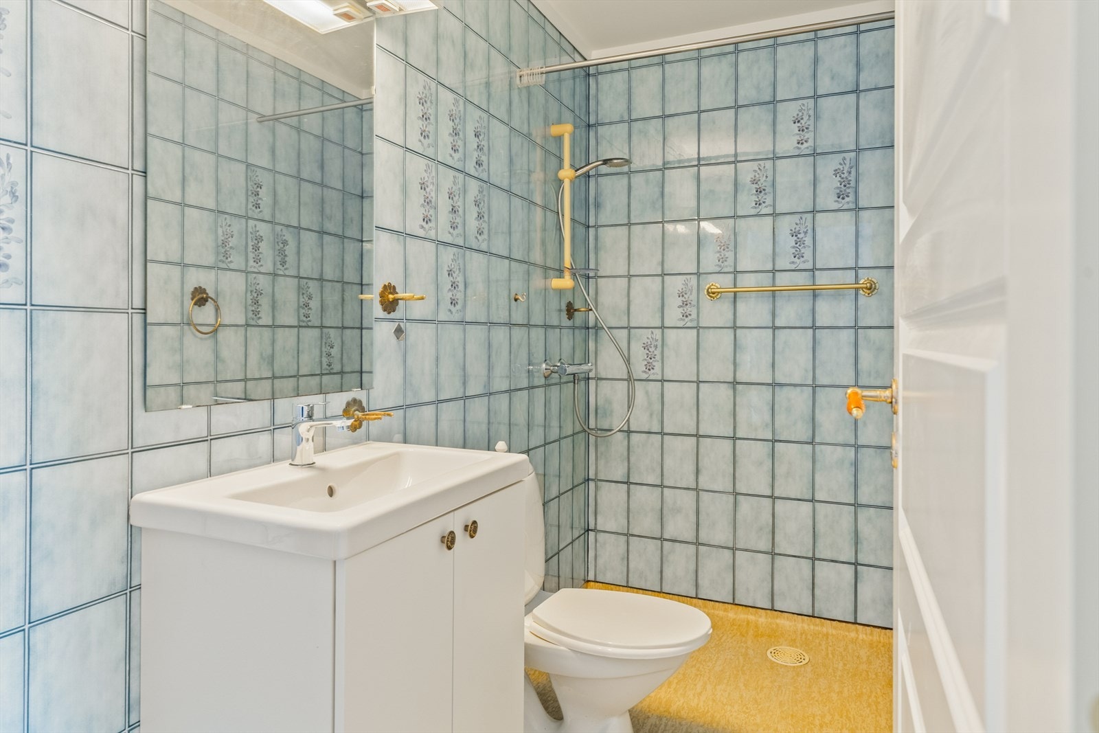 Badet har innredning med servant av nyere dato, toalett og dusj Galleribilde