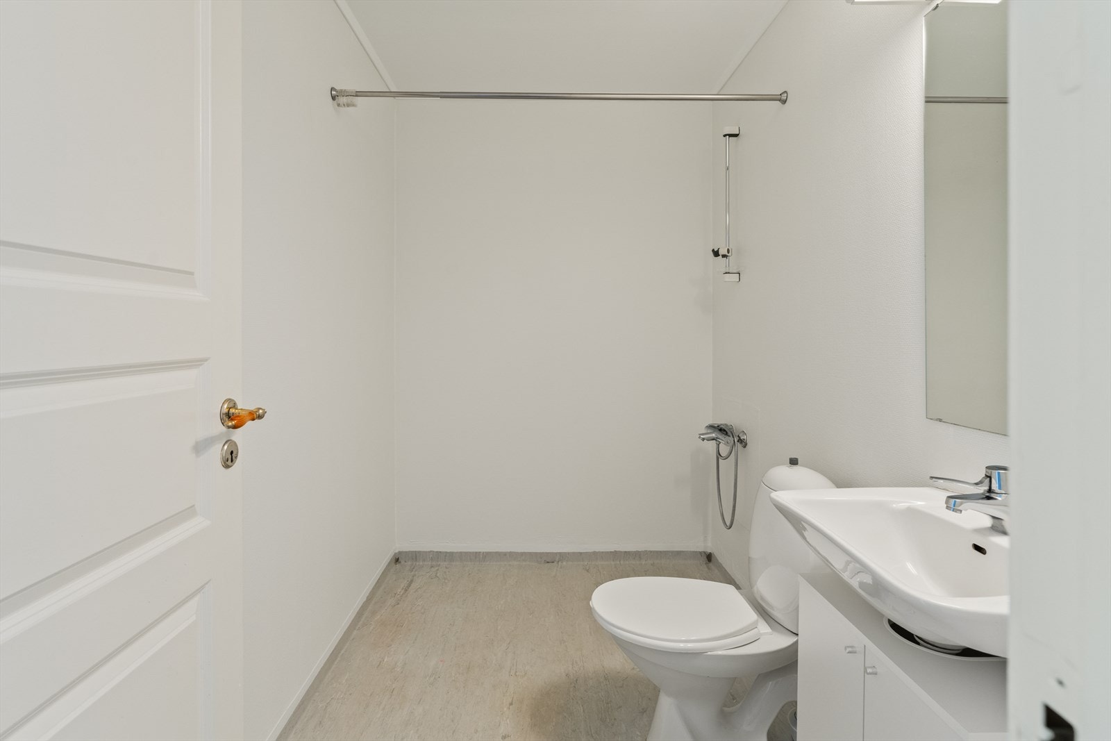 Badet har innredning med servant av nyere dato, toalett og dusj Galleribilde