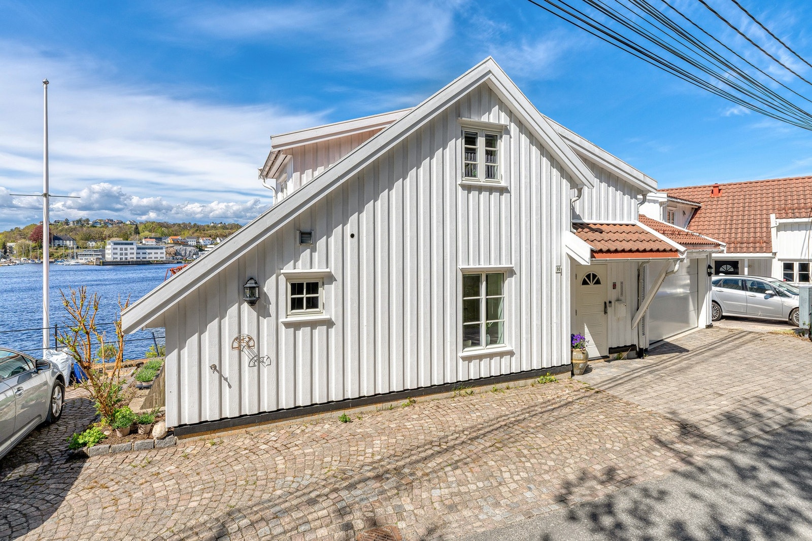 Eiendommen har gode parkeringsmuligheter med plass til opptil tre biler, i tillegg til tilhørende garasje hvor man kan gå tørrskodd inn i boligen for ekstra komfort og enkel hverdag. Galleribilde