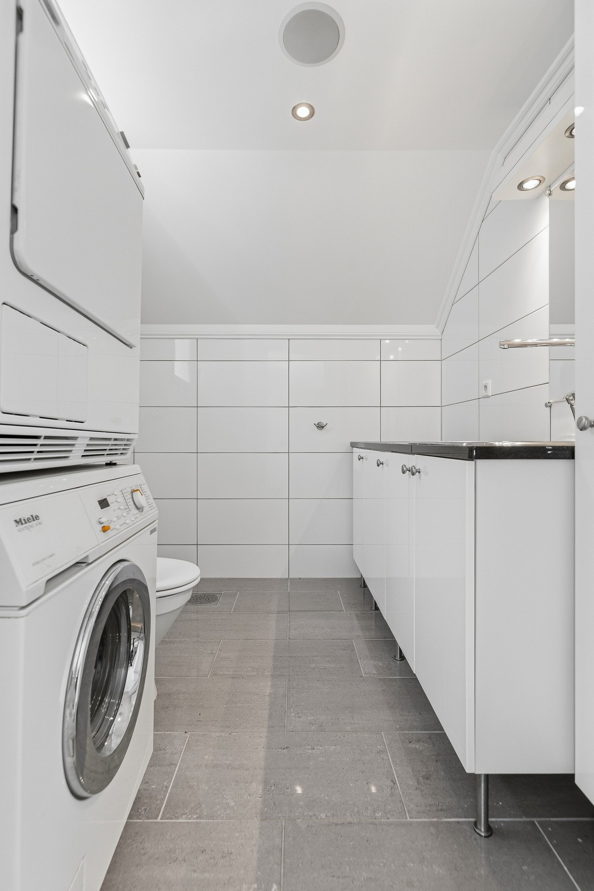 Hovedetasjen har et praktisk og romslig vaskerom med gjestetoalett og moderne innredning, gode oppbevaringsmuligheter og plass til både vaskemaskin og tørketrommel. Galleribilde