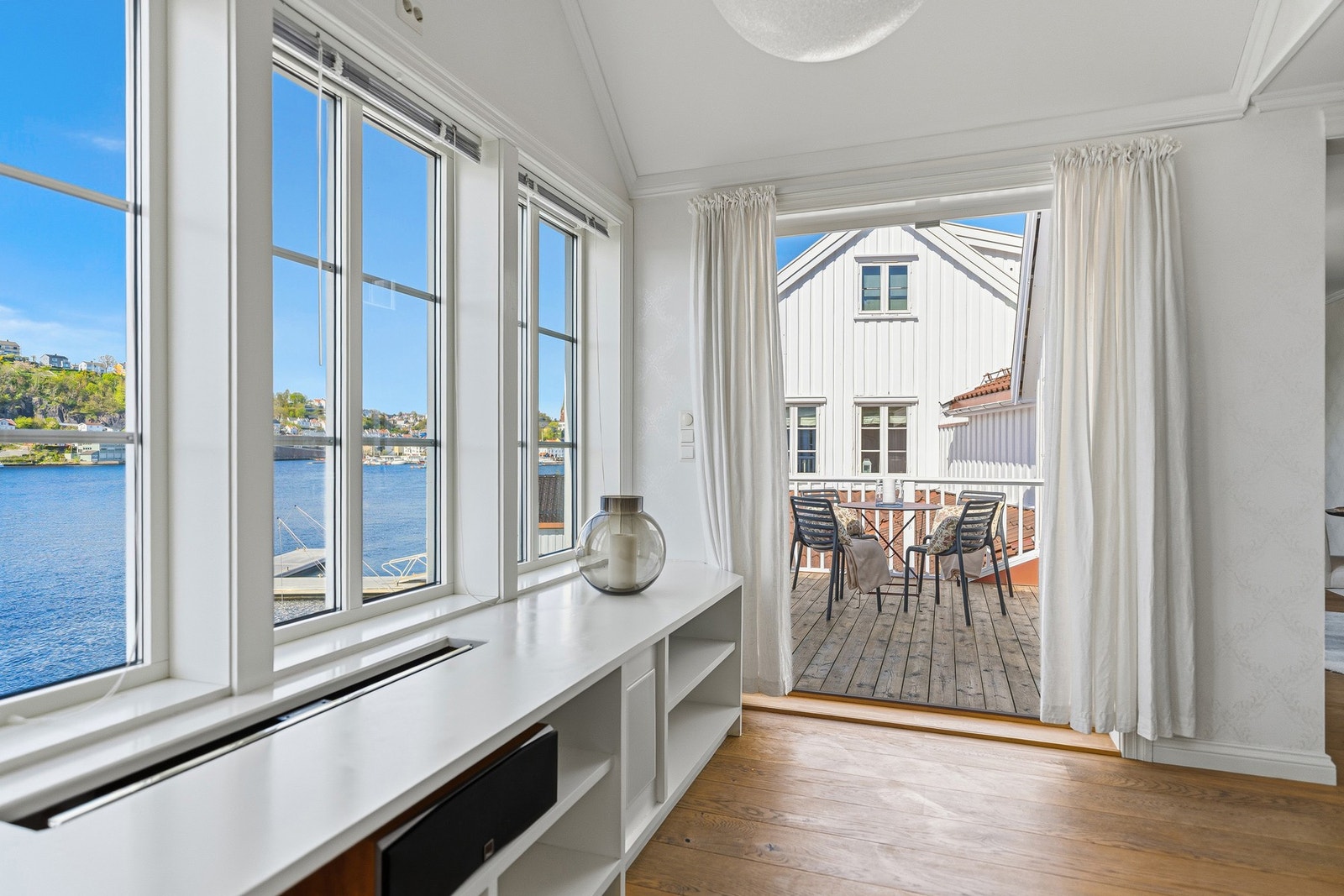 Fra stuen er det flott kontakt med sjøen og direkte utgang til terrassen - et herlig sted å nyte morgenkaffen med utsikt over vannet. Galleribilde