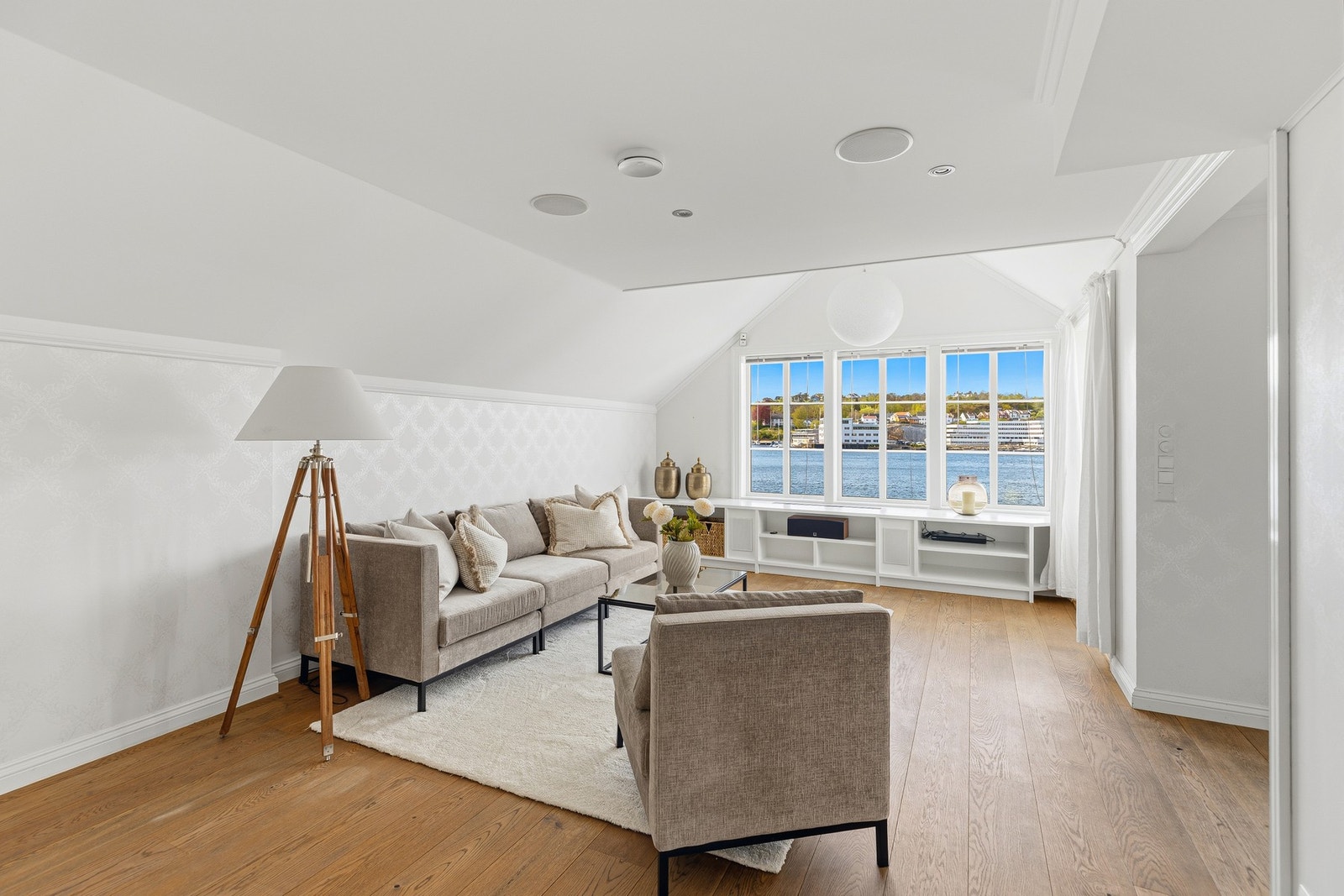 Lys og innbydende stue med store vindusflater som rammer inn den vakre sjøutsikten. Her skapes en lun og behagelig atmosfære med god plass til både sofagruppe og hyggelige samlinger. Galleribilde