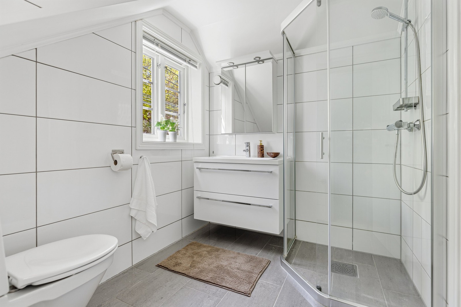 Badet er innredet med stilrene flater, praktisk dusjløsning og moderne baderomsinnredning som gir et tidløst og funksjonelt uttrykk. Galleribilde