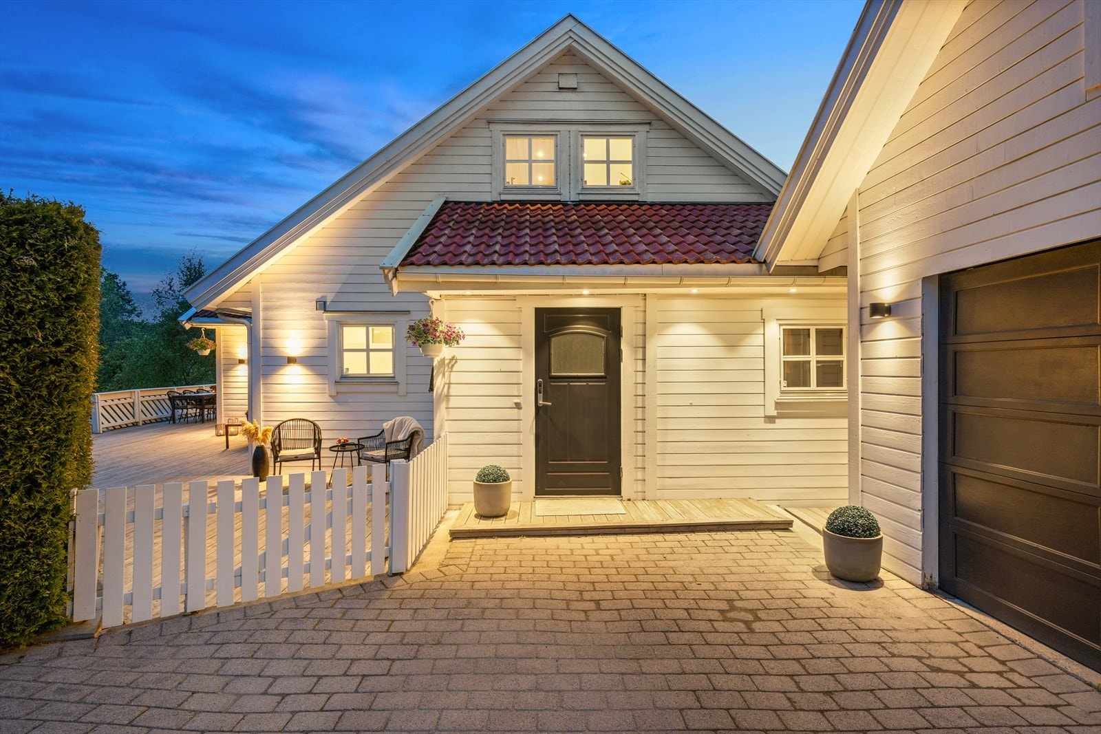 Huset har også garasje med loft, steinbelagt gårdsplass og et innbydende inngangsparti. Galleribilde