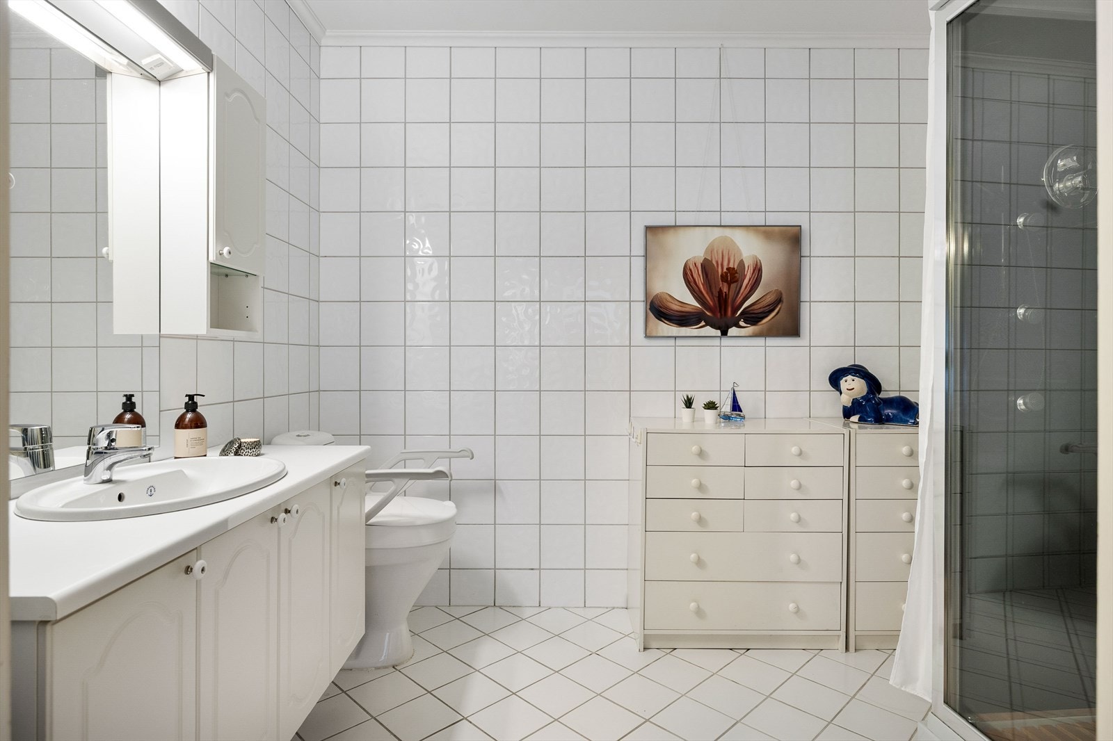 Badet er innredet med servant i innredning, toalett og dusjkabinett. Galleribilde