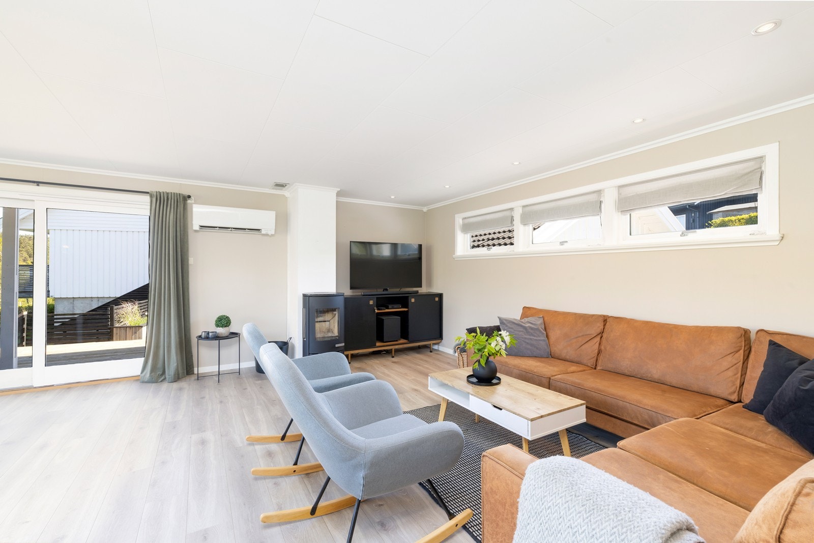 Tilbake i stuen finner du god plass til både sofagruppe og spisestue. Legg også merke til både peisovn og varmepumpe. Galleribilde