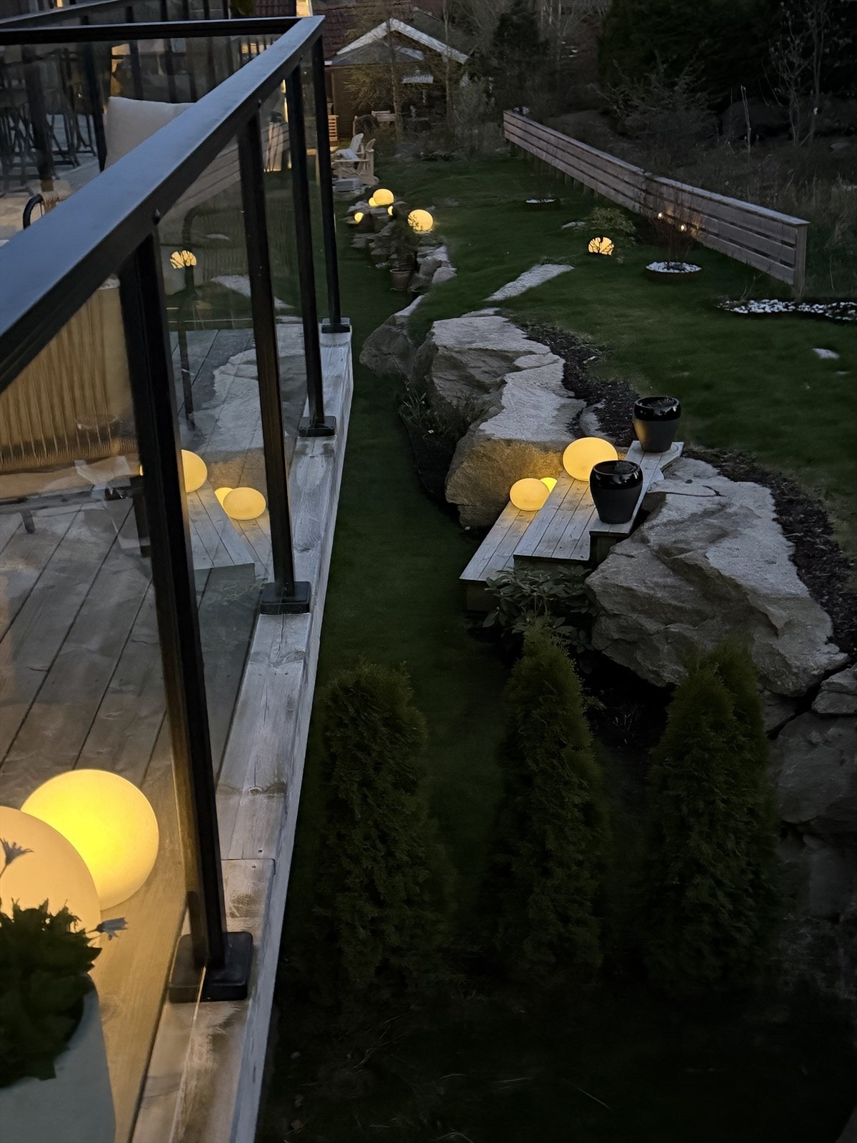 Hagen er pent opparbeidet med plen, beplantning og synlig fjell. Galleribilde