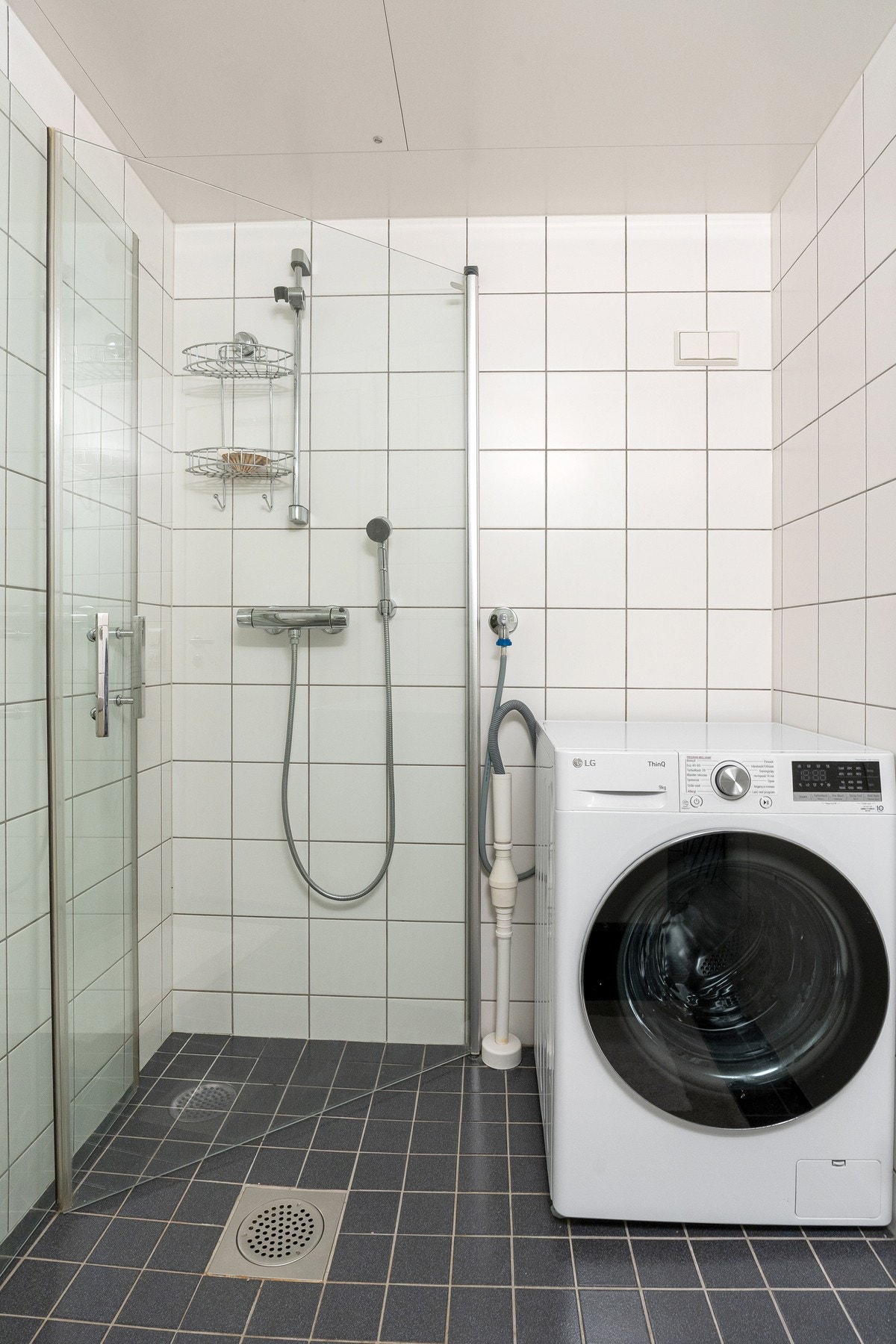 Baderommet er flislagt og fra byggeår. Rommet er innredet med servantskap med glatte, folierte fronter og heldekkende servant, speil og lysarmatur på vegg over servant, opplegg for vaskemaskin, dusjhjørne med svingdører, håndholdt dusjhode og termostatsty Galleribilde
