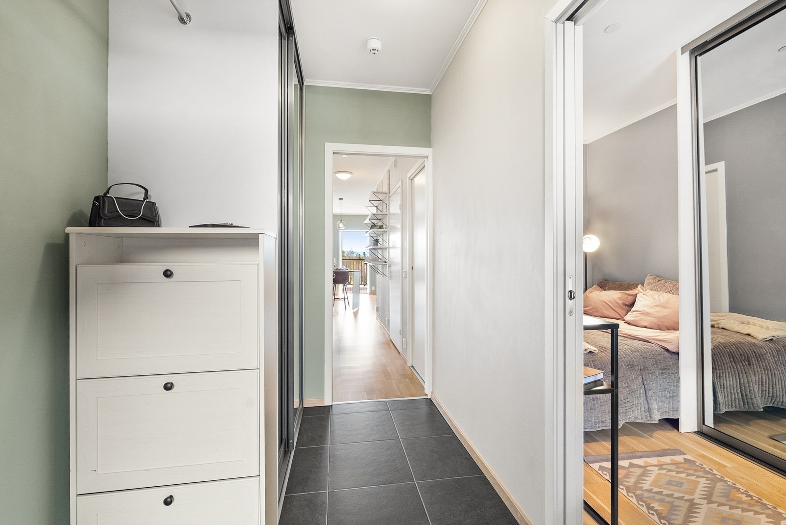 Entre med fine fargevalg og varme i gulv. Gode oppbevaringsmuligheter i speil skyvedørsgarderobe. Galleribilde