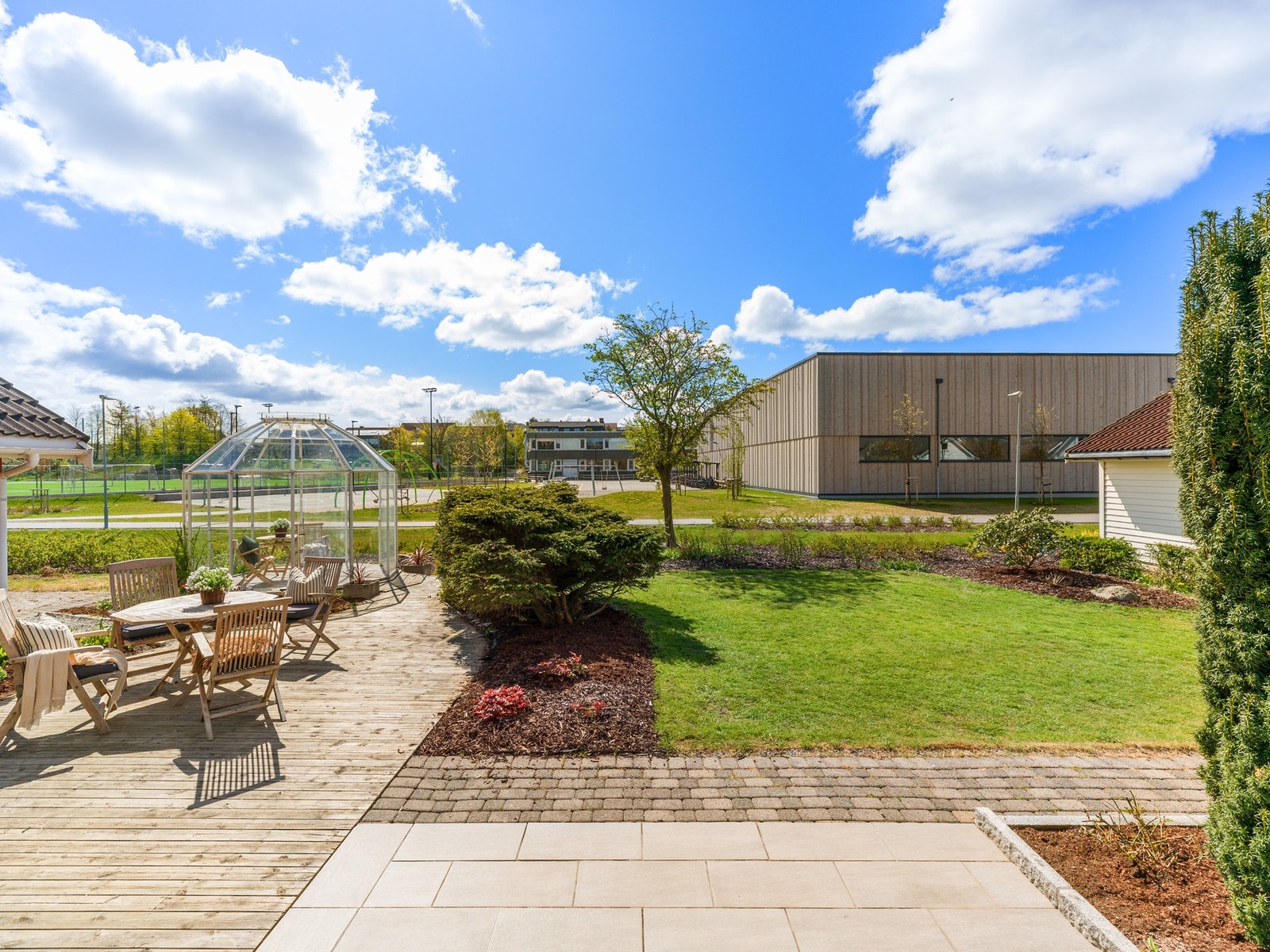 Tomten er flott opparbeidet med terrasse, belegningsstein, plen og flott beplantning. Galleribilde