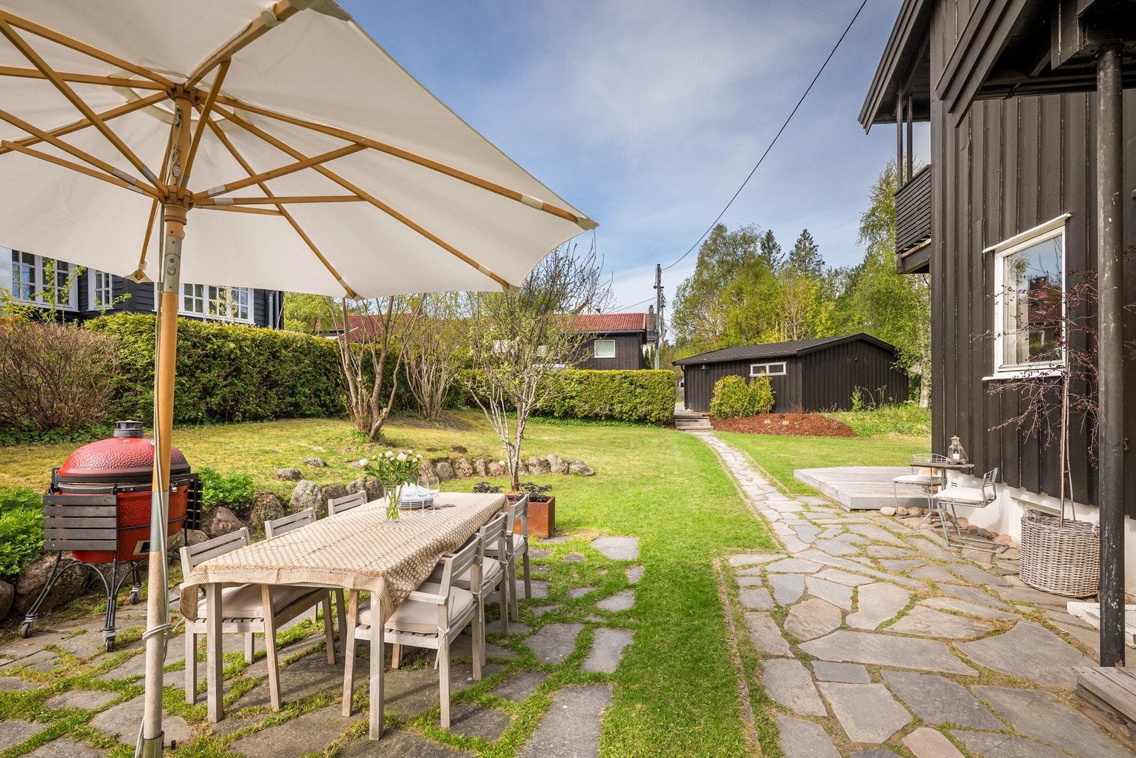 Eiendommen er flat og lettstelt, inngjerdet med hekk som gir lite innsyn. Galleribilde