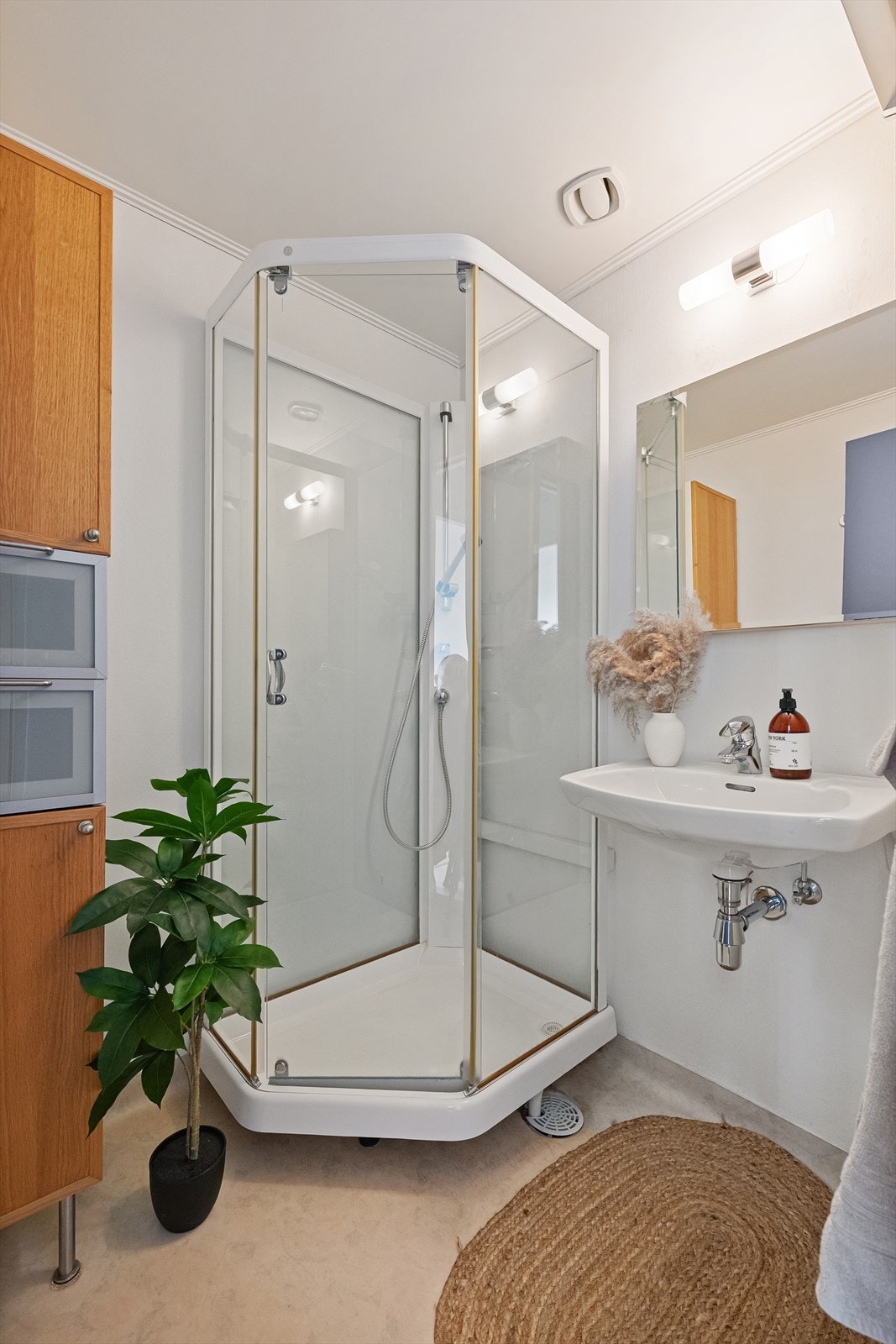 Badet er utstyrt med dusjkabinett og servant. Galleribilde