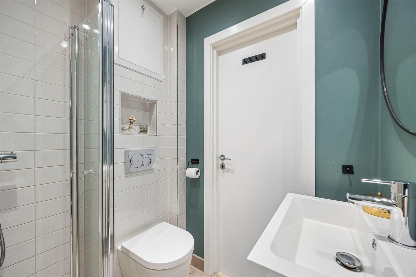 Badet er praktisk utstyrt med vegghengt toalett, dusjhjørne med glassvegger samt opplegg for mulig vaskemaskin. Galleribilde